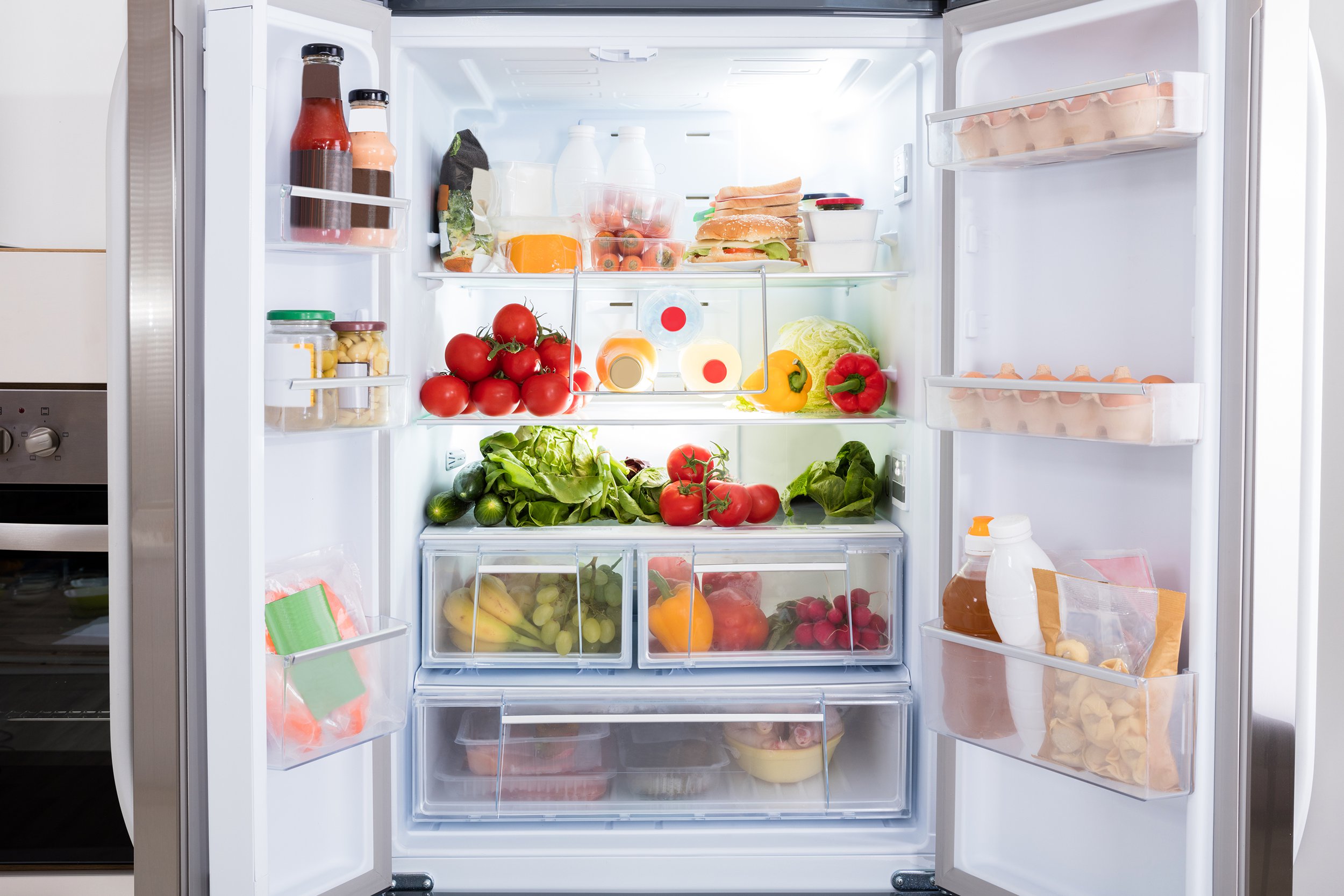 View of an open fridge full of produce