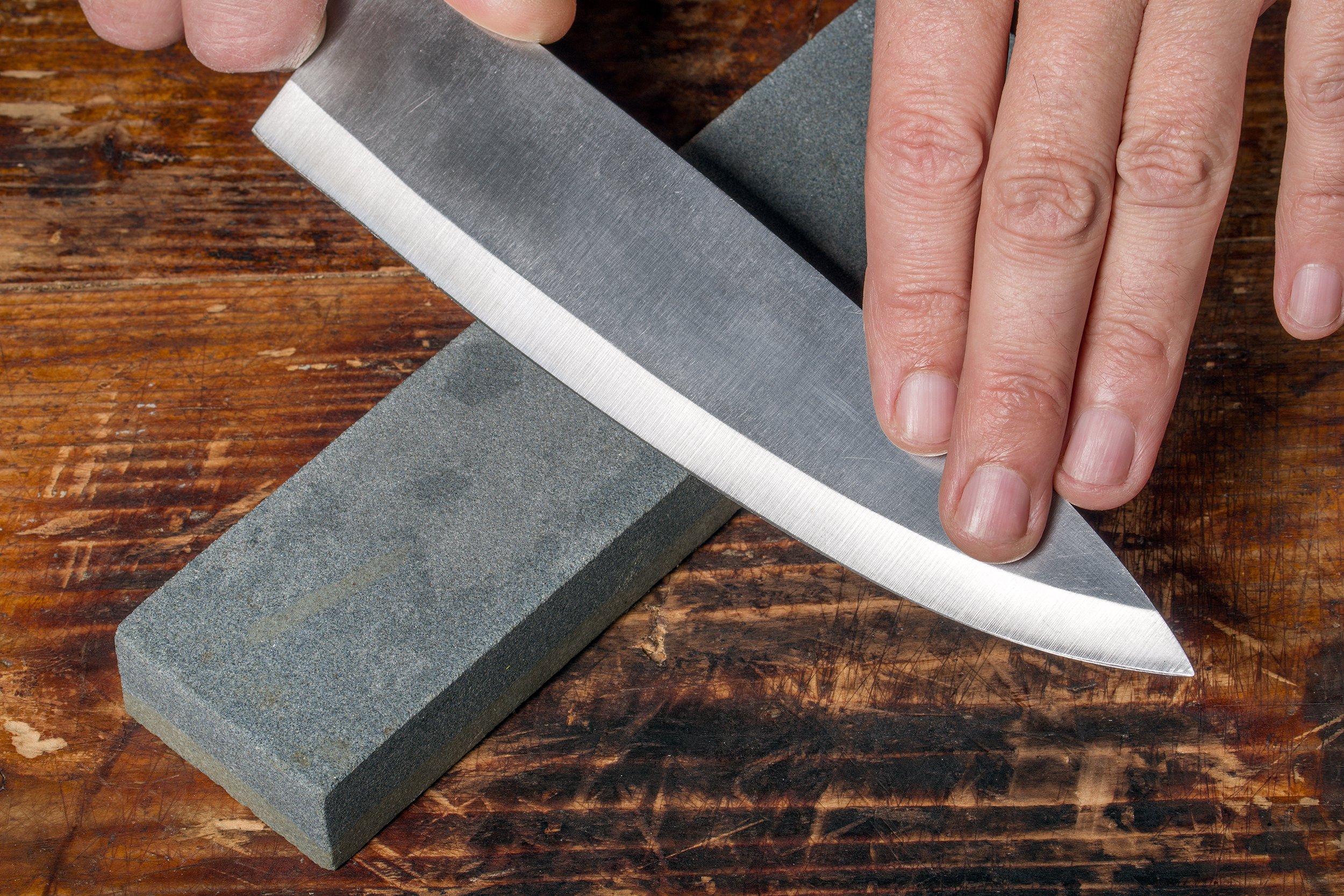 Man sharpening a knife on a wetstone