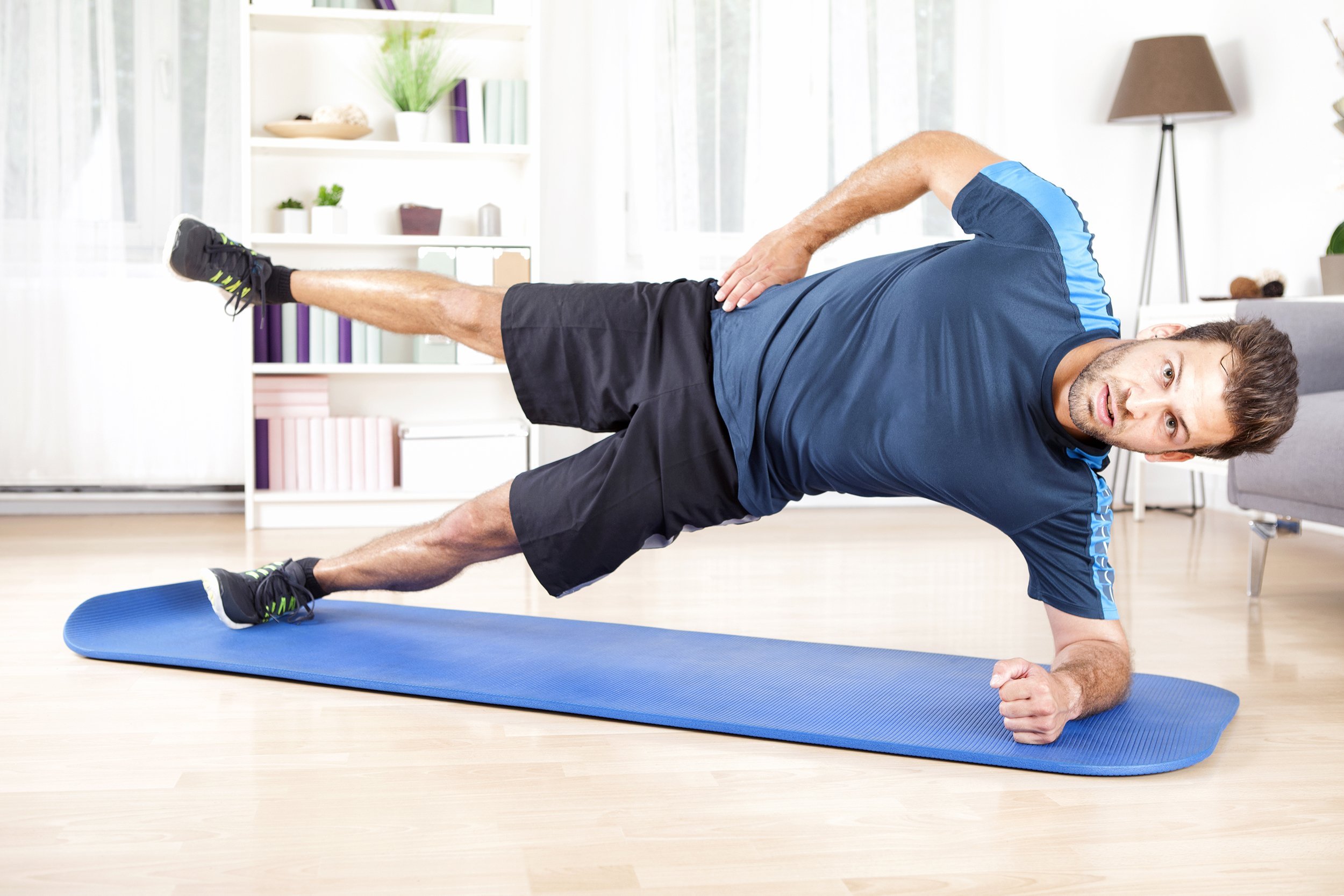 man doing side plank in his home