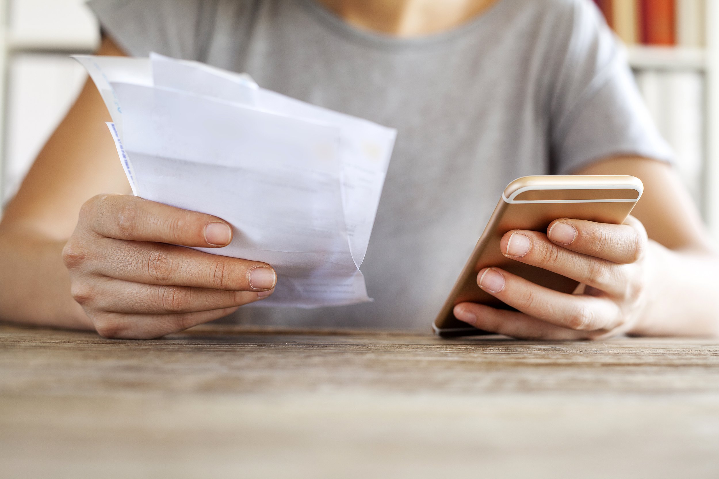 Woman looking at cell phone bill