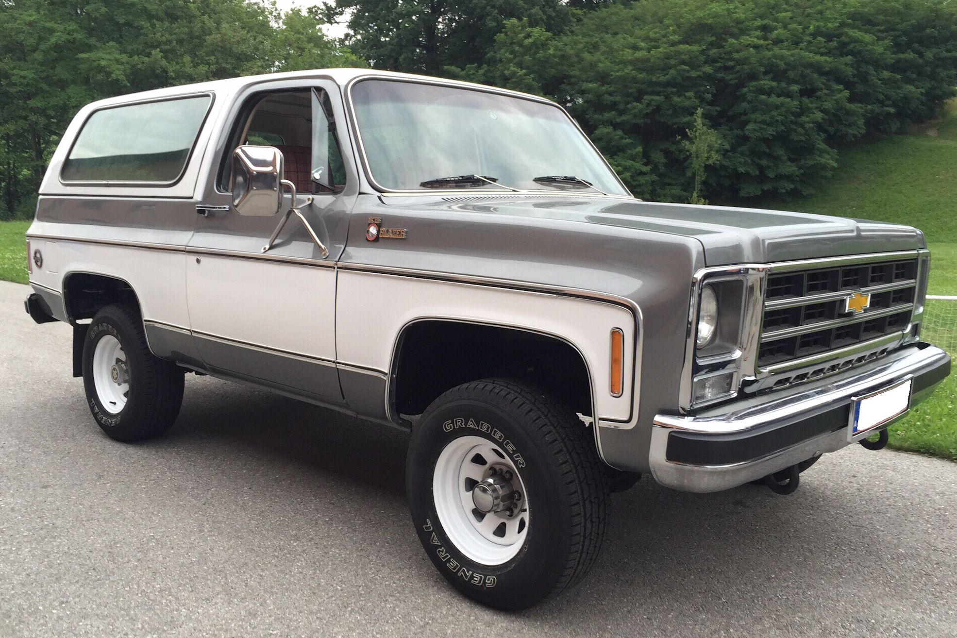 Beige and gray 1979 Chevrolet K5 Blazer Cheyenne parked next to green lawn.