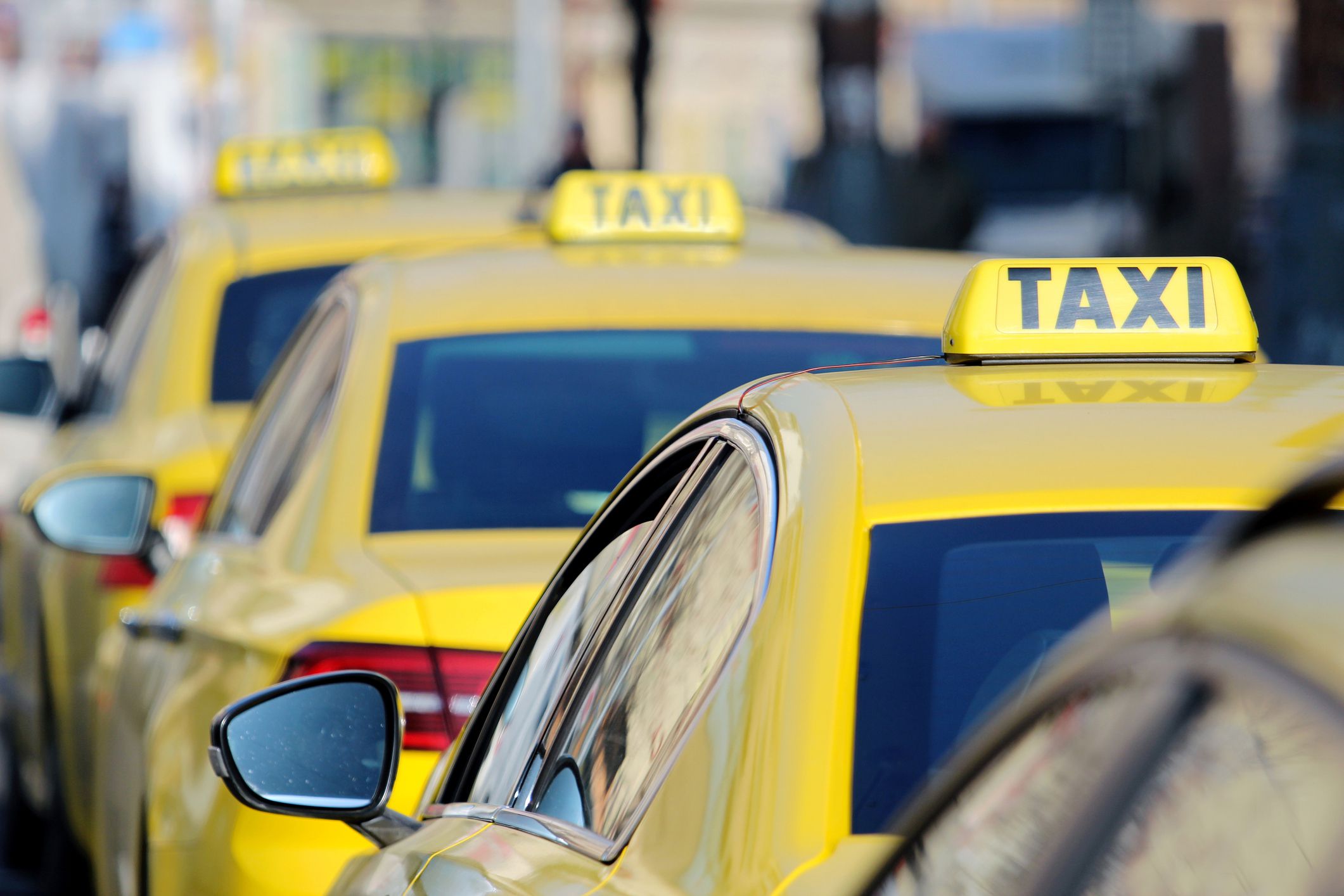 Closeup row of four taxis blurred background of city
