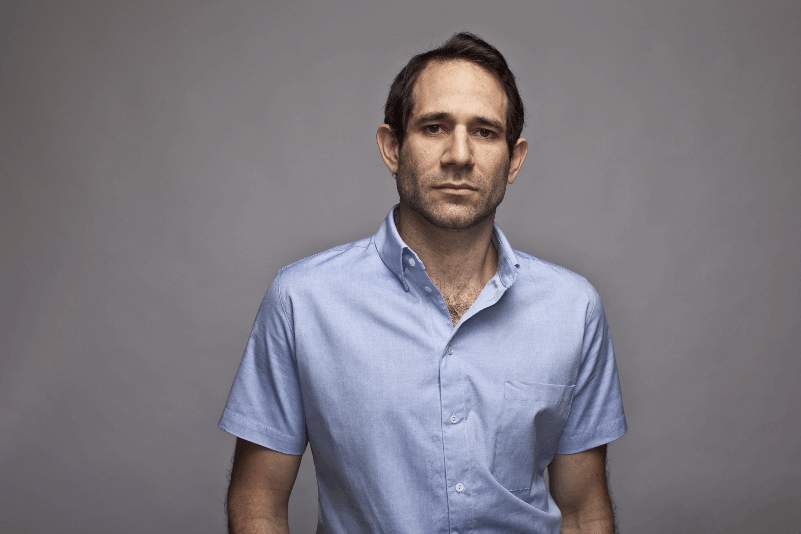 Dov Charney poses for a portrait photo, New York City, 2009, dark grey background