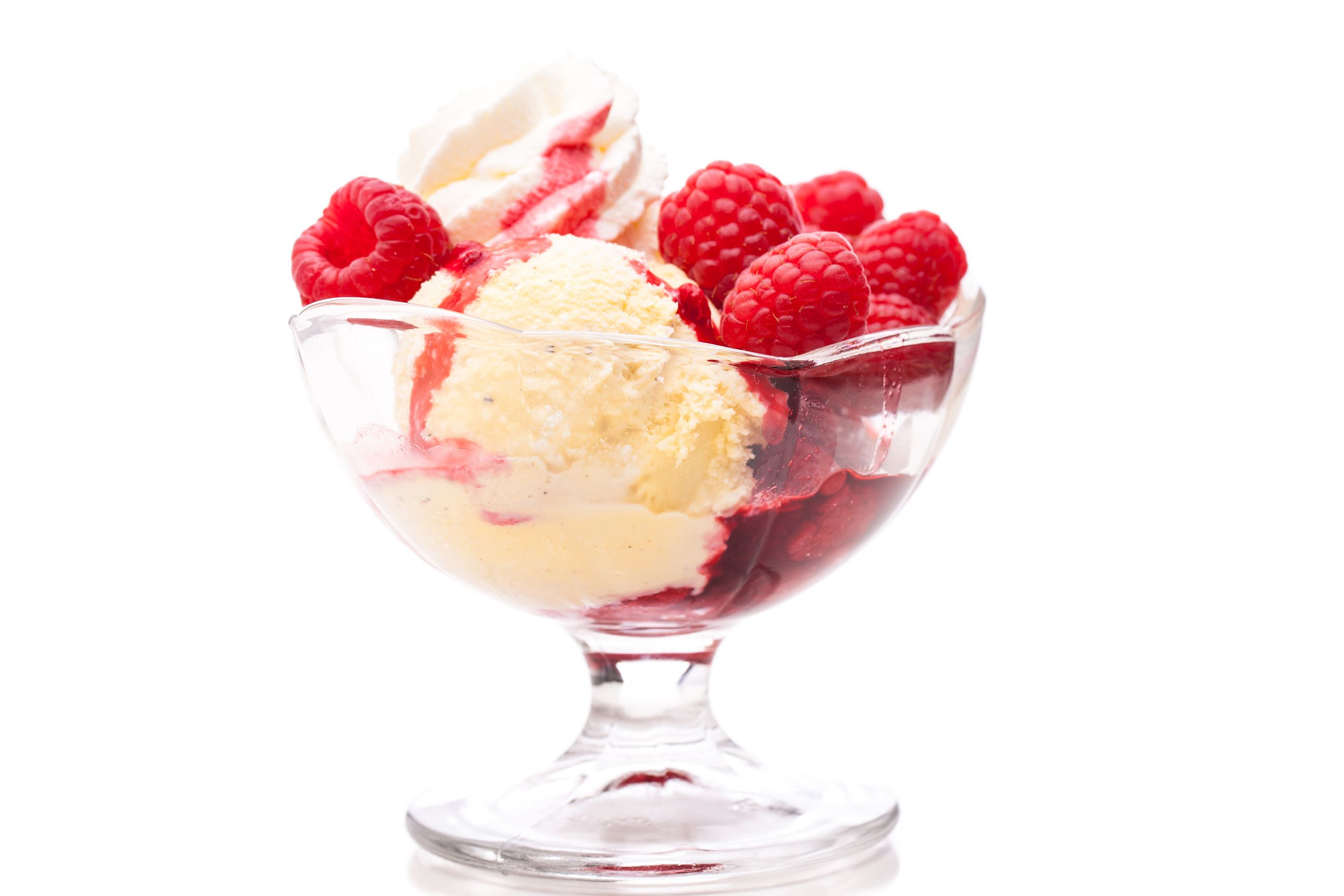Fruit compote a la mode in a glass dessert cup with a white background