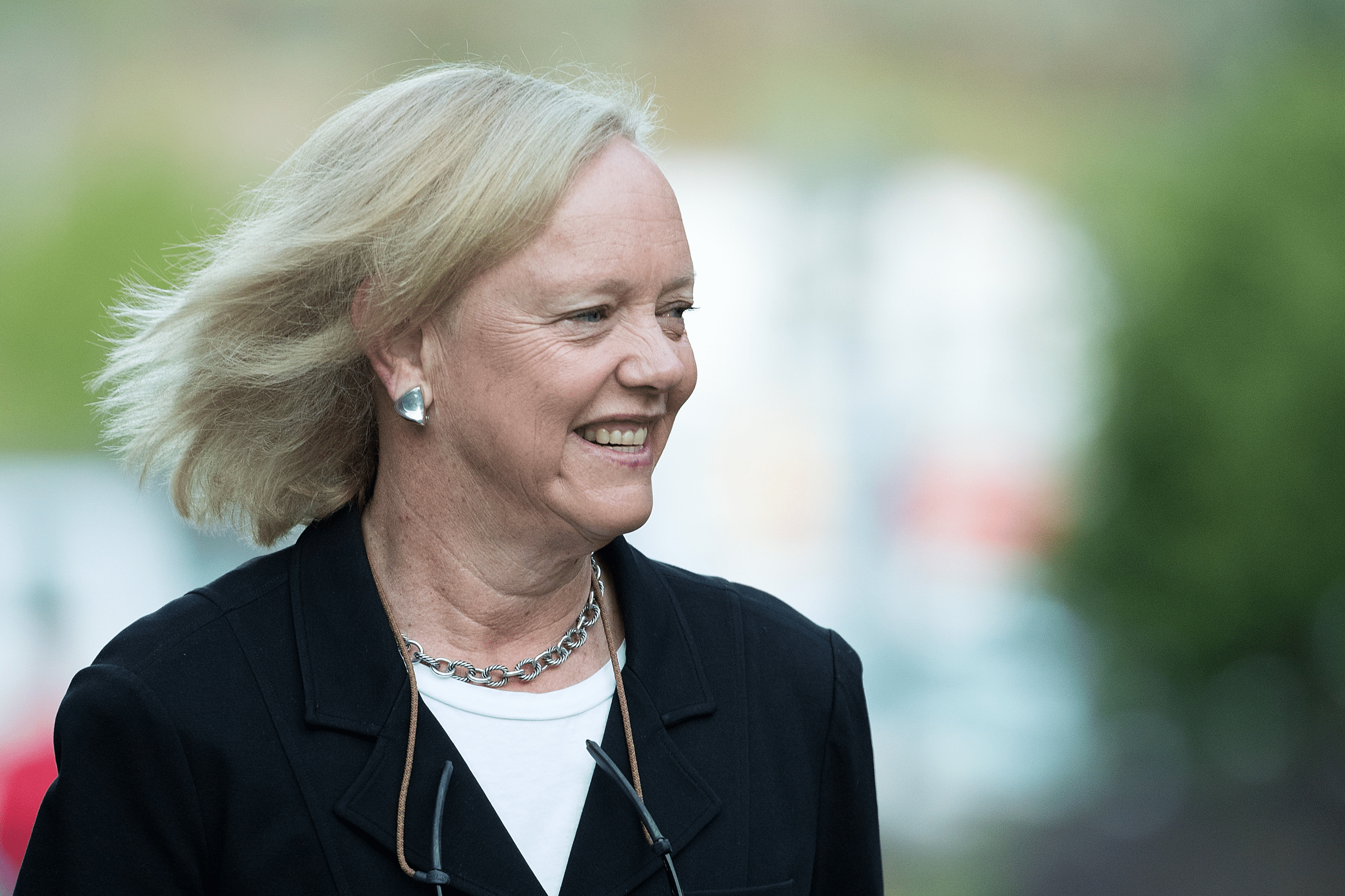 Slight sideview portrait of Meg Whitman at the Annual Allen & Company Sun Valley Conference, Sun Valley, Idaho, 2016, blurred background of greenery outside
