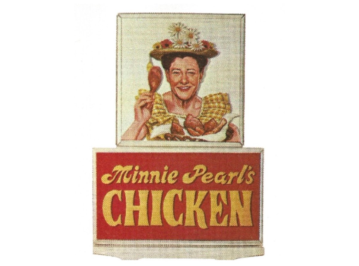 A smiling woman in a flowered hat holds a chicken drumstick and a plate of chicken and waffles above a sign that reads "Minnie Pearl's Chicken" in yellow letters on red, recalling the charm of old restaurant chains.