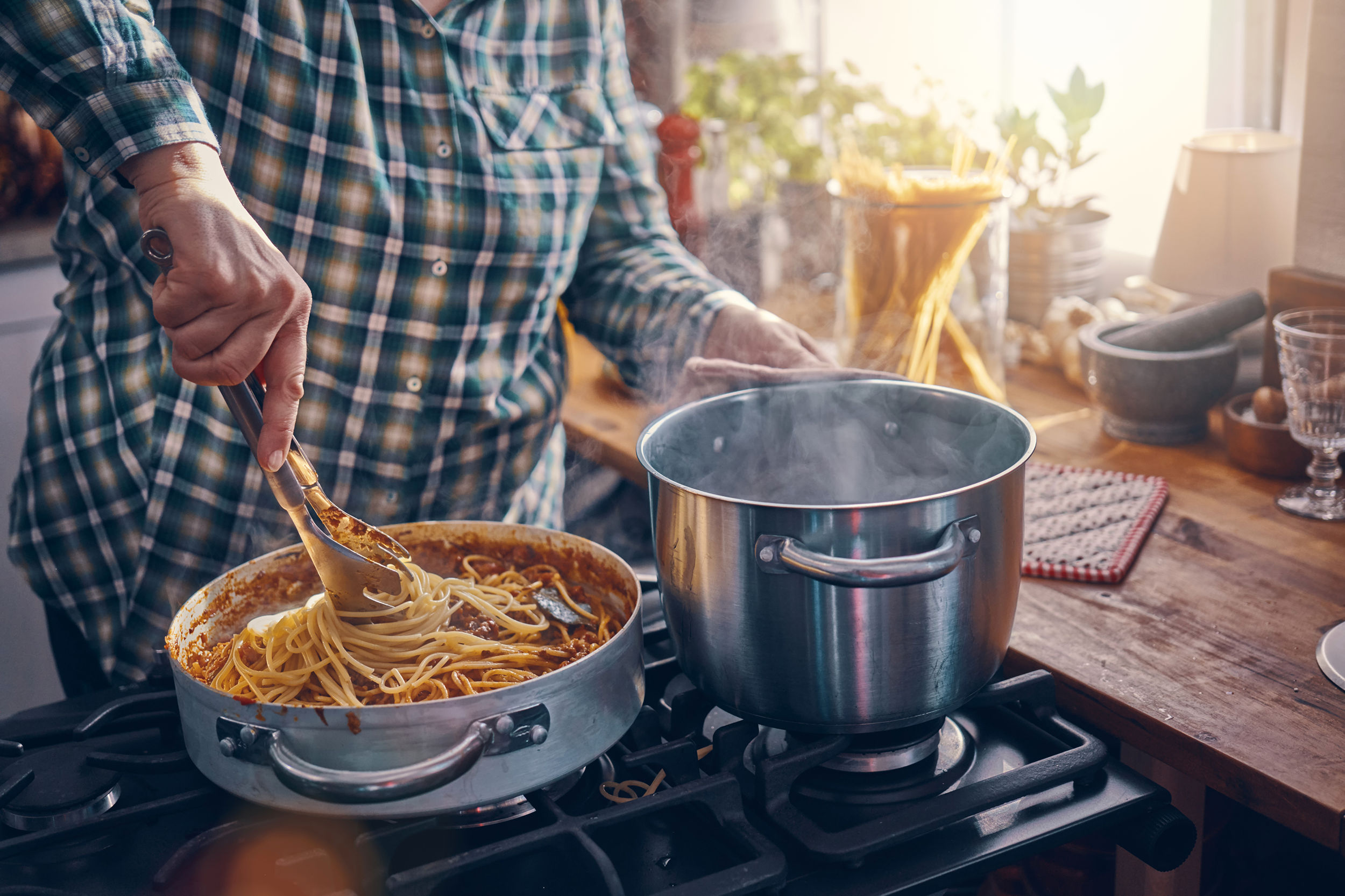 Woman preparing spaghetti with meat sauce