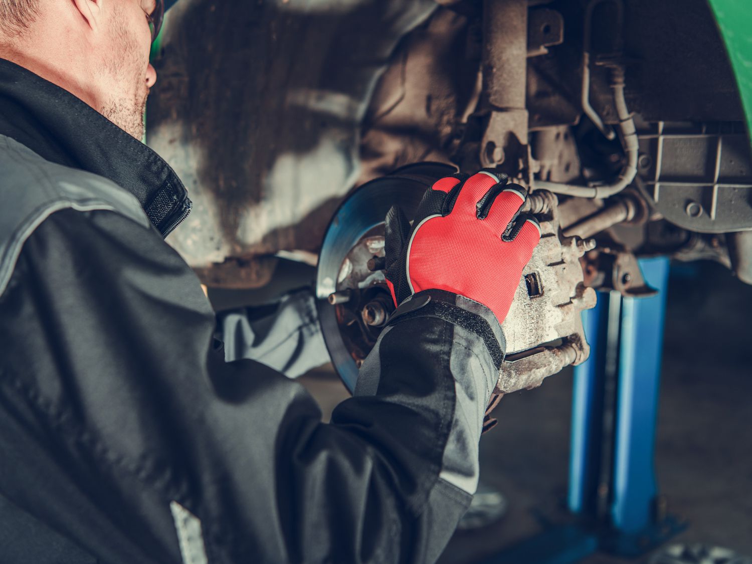 Automotive Industry. Car Brakes Maintenance Performed by Caucasian Auto Service Mechanic.