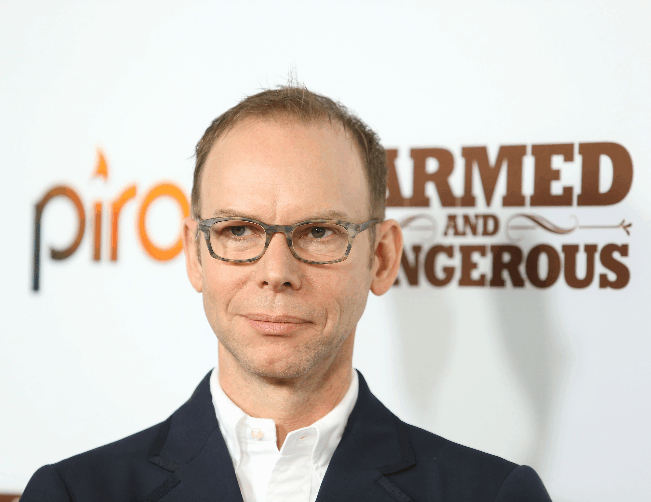 Portrait of Steve Ells as he arrives at the Chipotle world premiere of the original comedy web series 'Farmed and Dangerous' held at DGA Theater, Los Angeles, 2014, white background with gold lettering of the web series