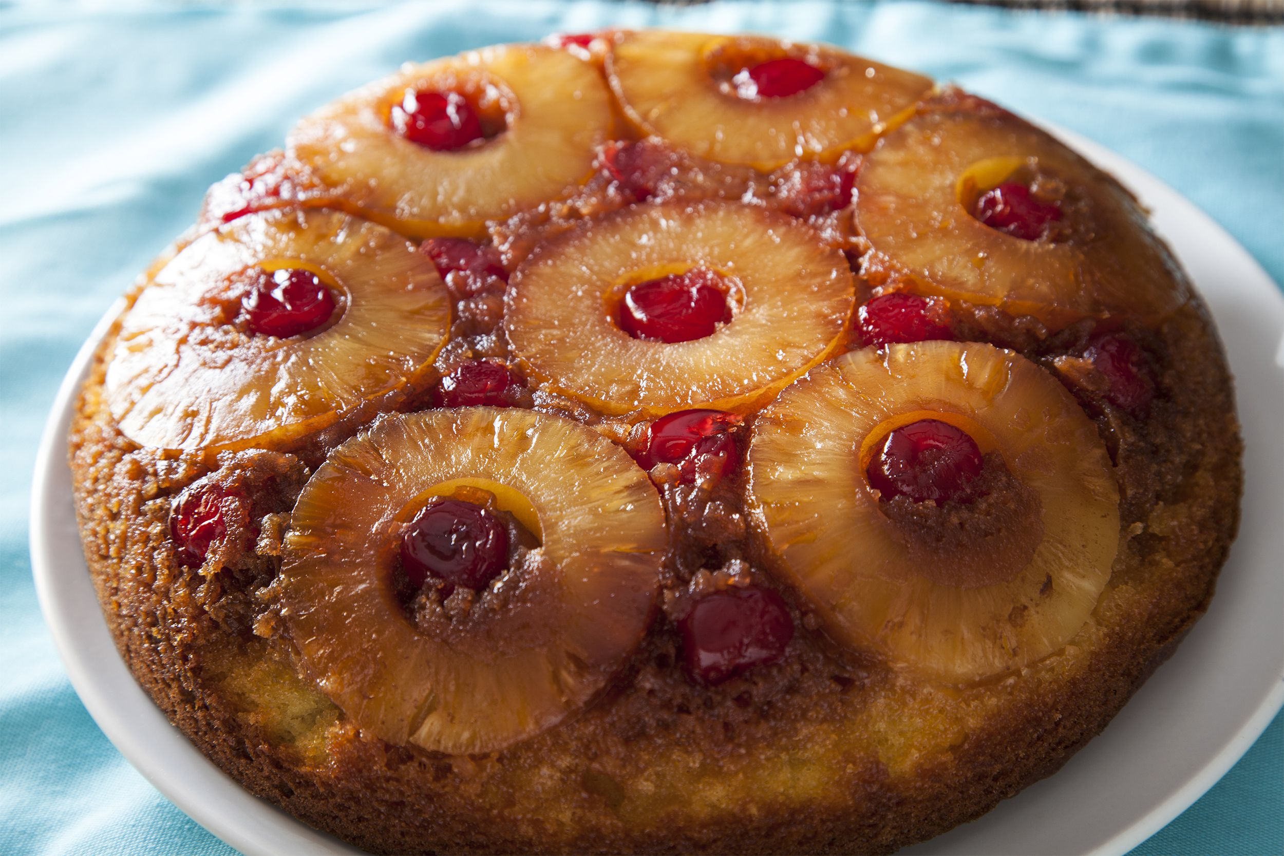 Sugar-free pineapple lush cake on a white plate on a light blue satin tablecloth