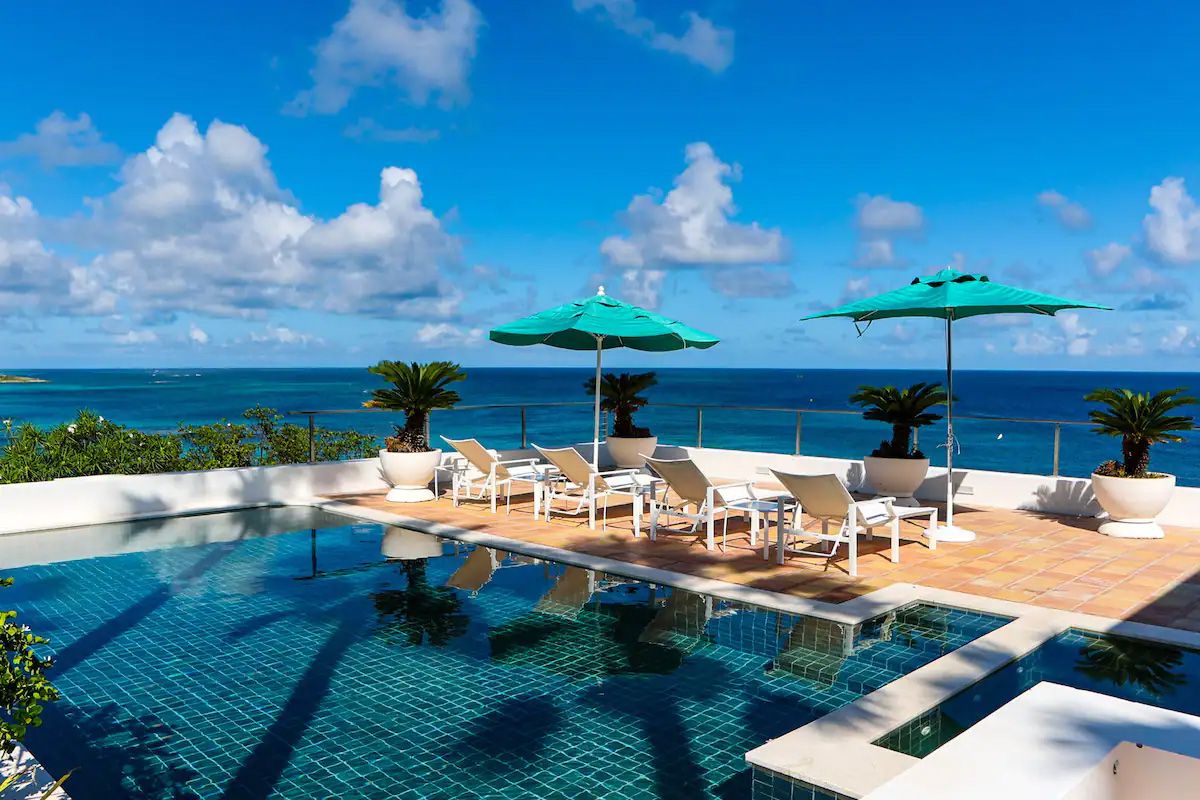 The Villa Stella Maris pool, with adjacent terrace and ocean view in the background