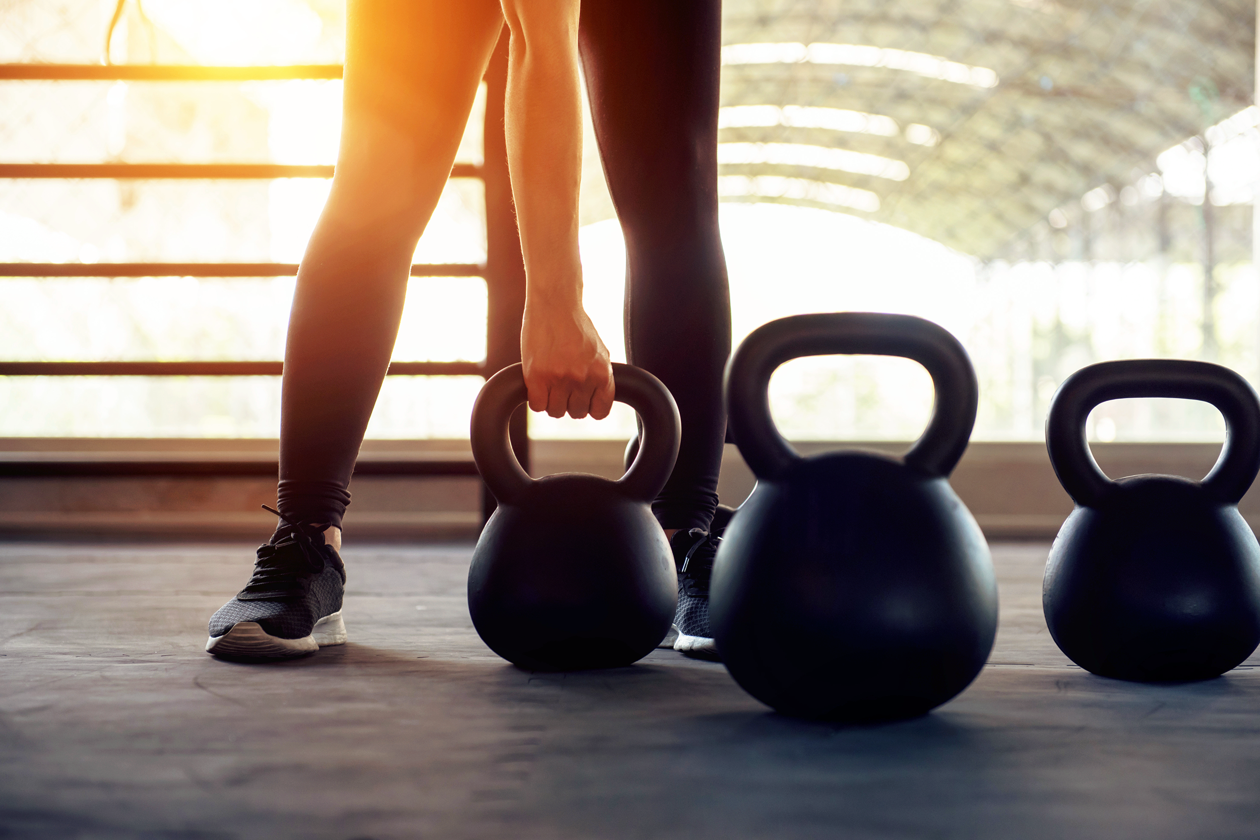 Woman grabbing kettlebells