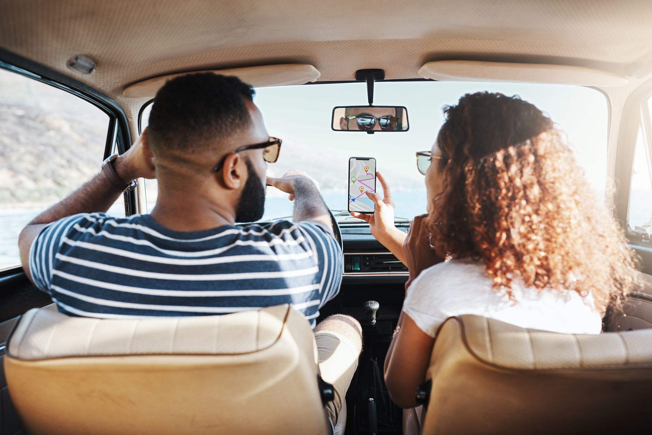 Shot of a young couple using gps on their mobile phone during a road trip
