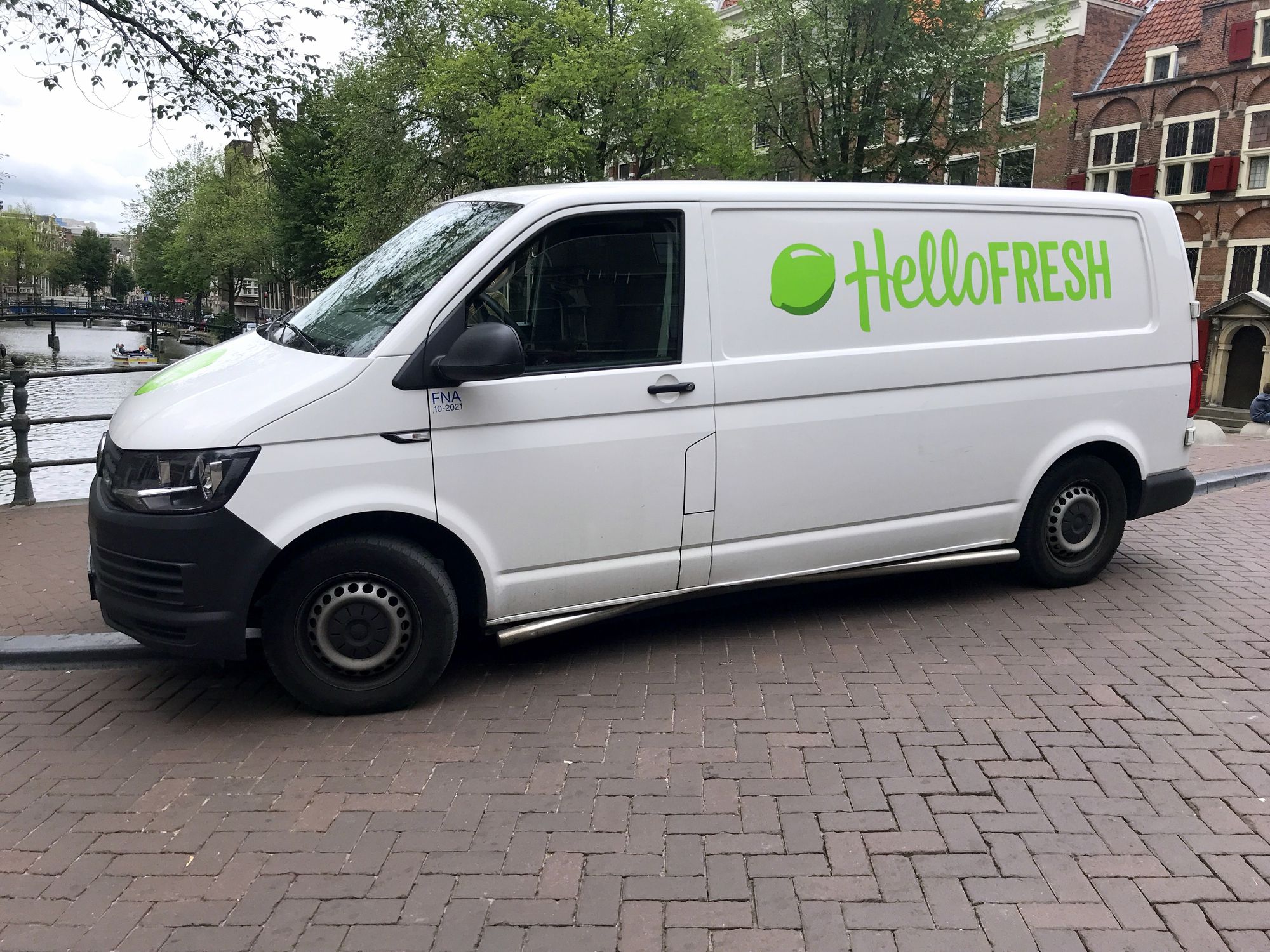 Amsterdam, the Netherlands - July 15, 2019: White Volkswagen Transporter HelloFresh delivery van parked by the side of the road. Nobody in the vehicle.