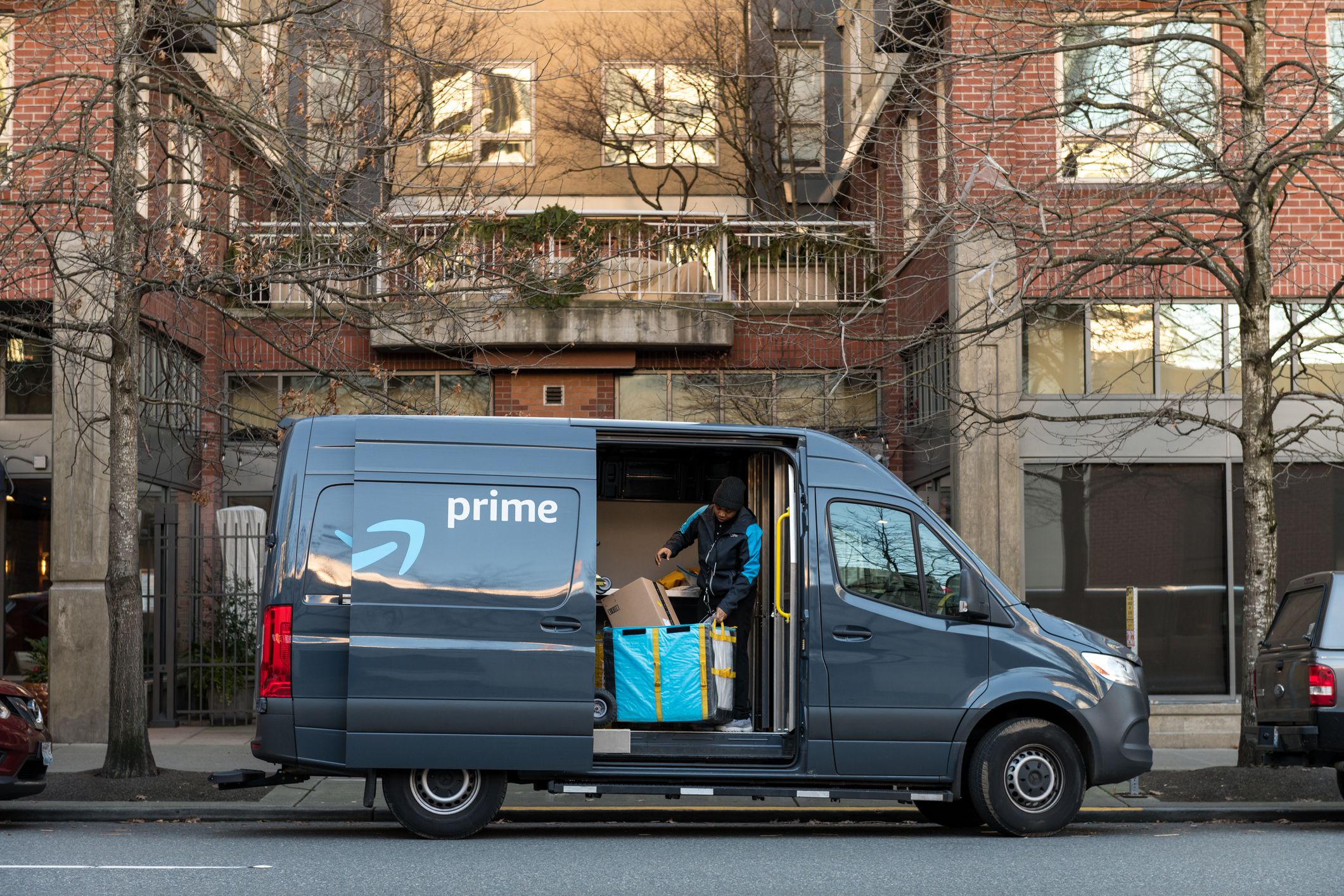 Seattle, USA - Feb 10, 2020: Amazon Prime Now Delivery van and driver downtown on 4th avenue late in the day