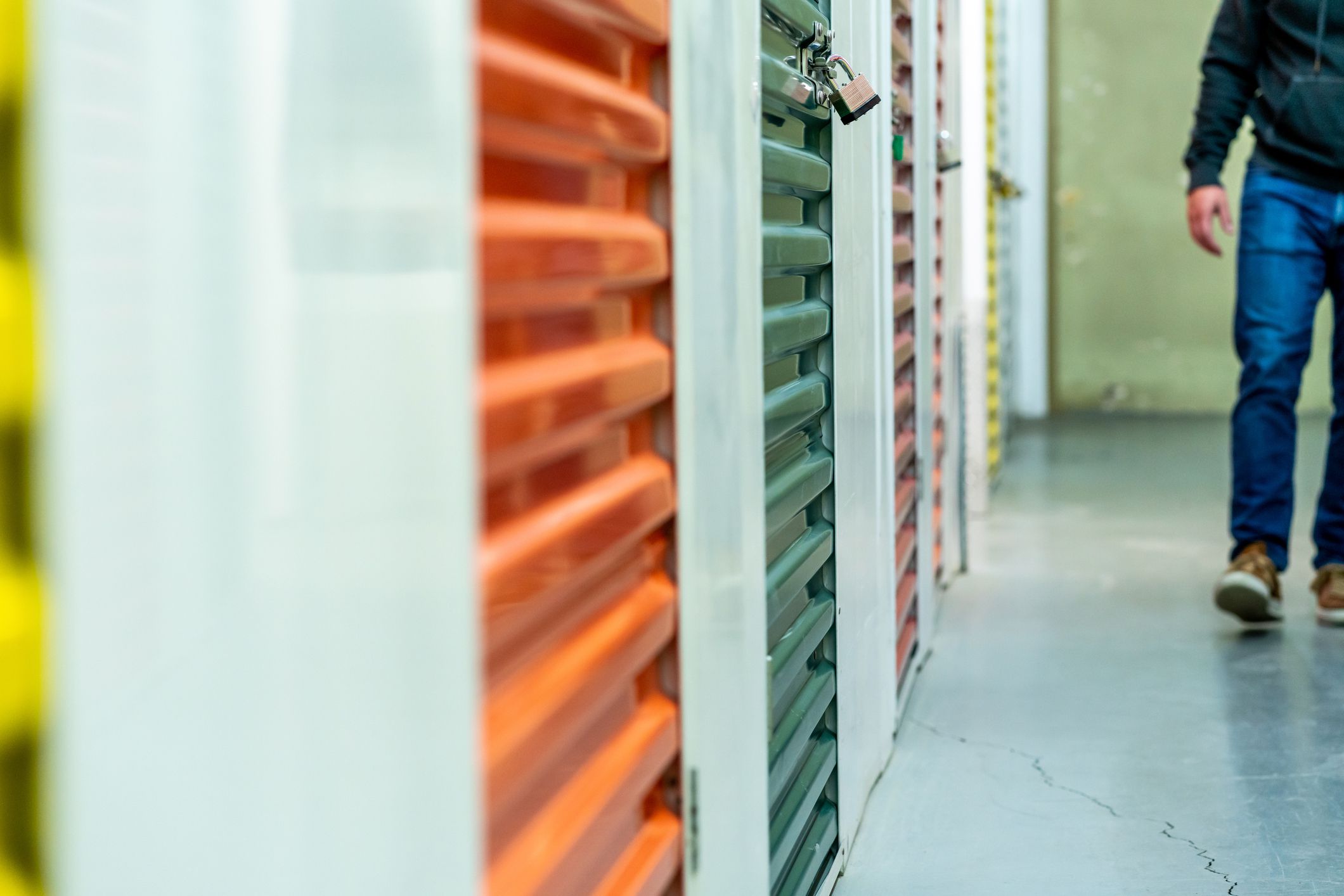 Man walking in a corridor full of storage units.