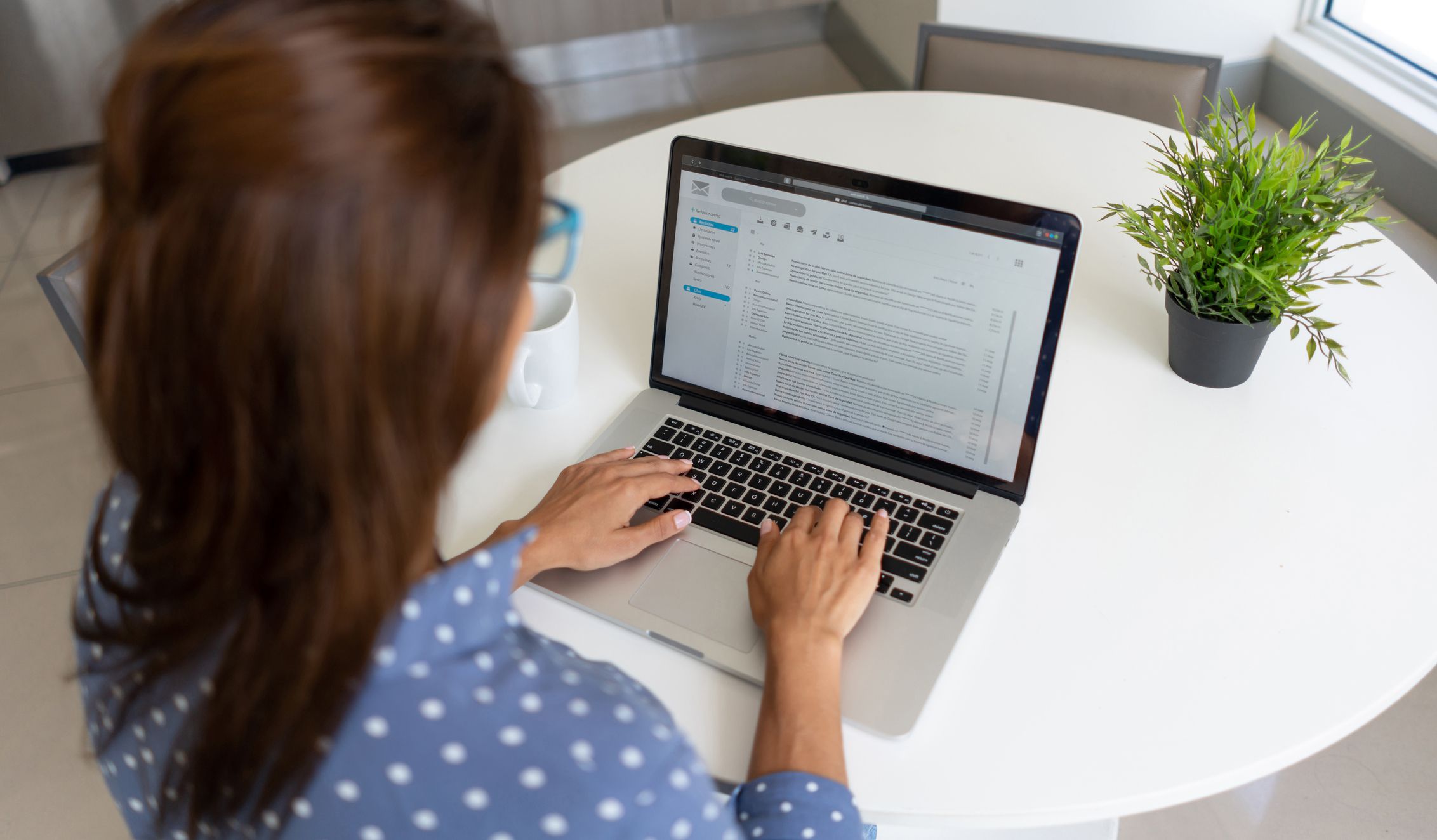 Latin American woman telecommuting and reading her e-mail on a laptop at home - lifestyle concepts
