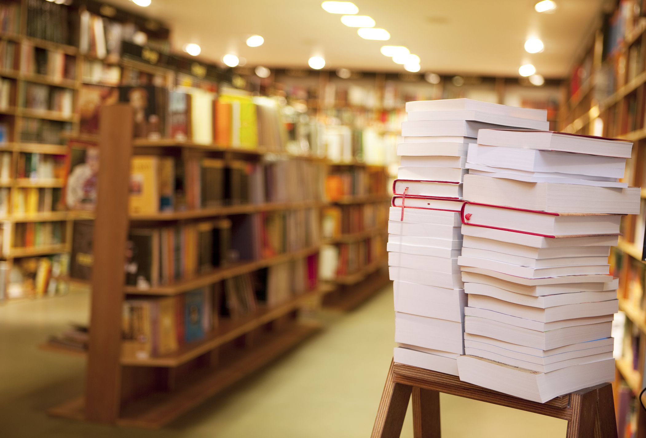 pile of books on the ladder, defocused library is in back of books