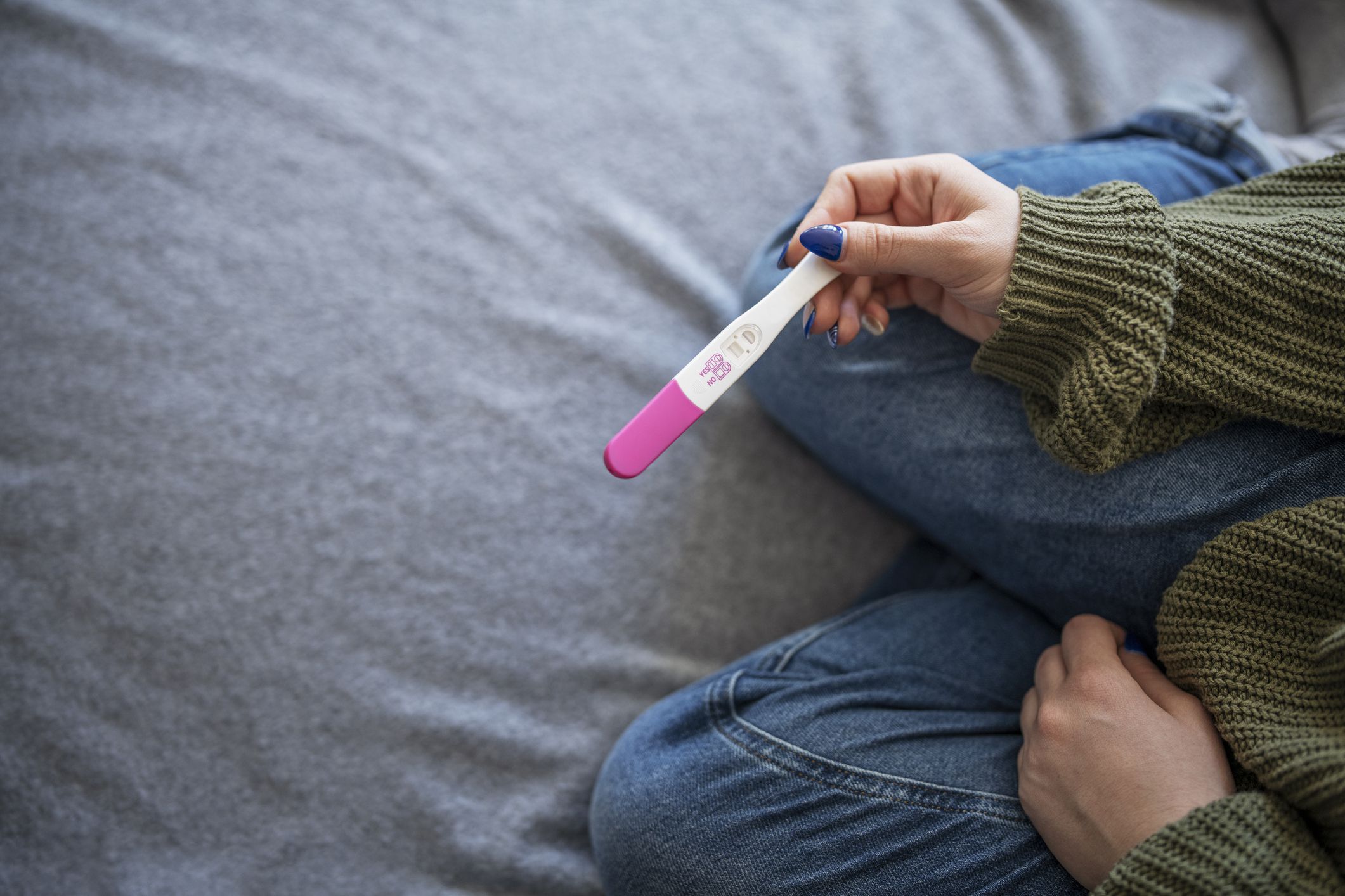 Unrecognisable woman holding positive pregnancy test.