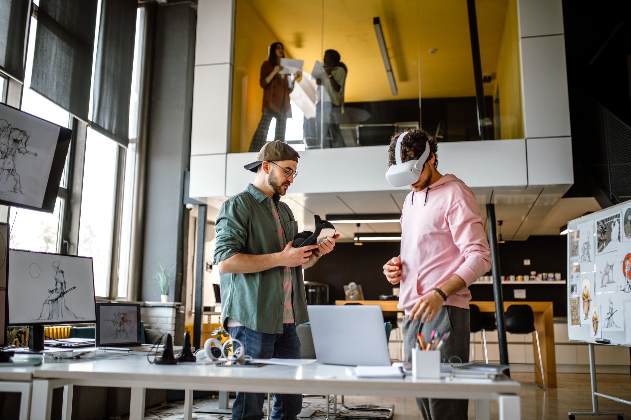 Group of colleagues in company office using virtual reality simulator headsets to test new video game they are creating.