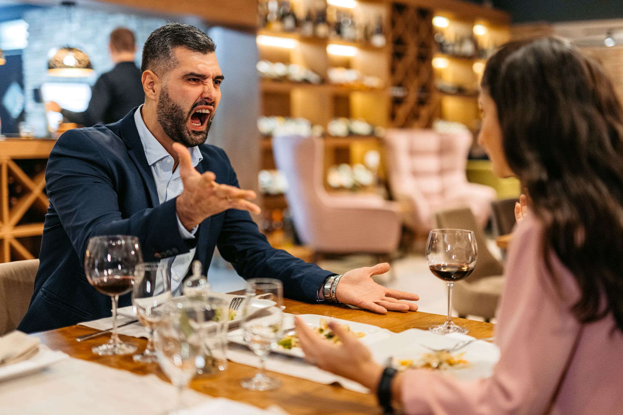 Mid adult couple arguing while having dinner at the restaurant.