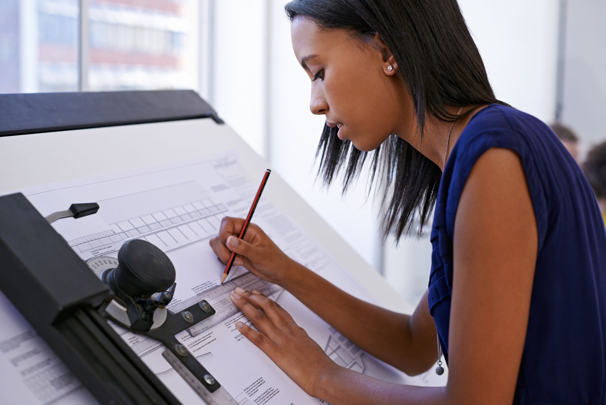Cropped shot of an attractive female architect working at a drawing board