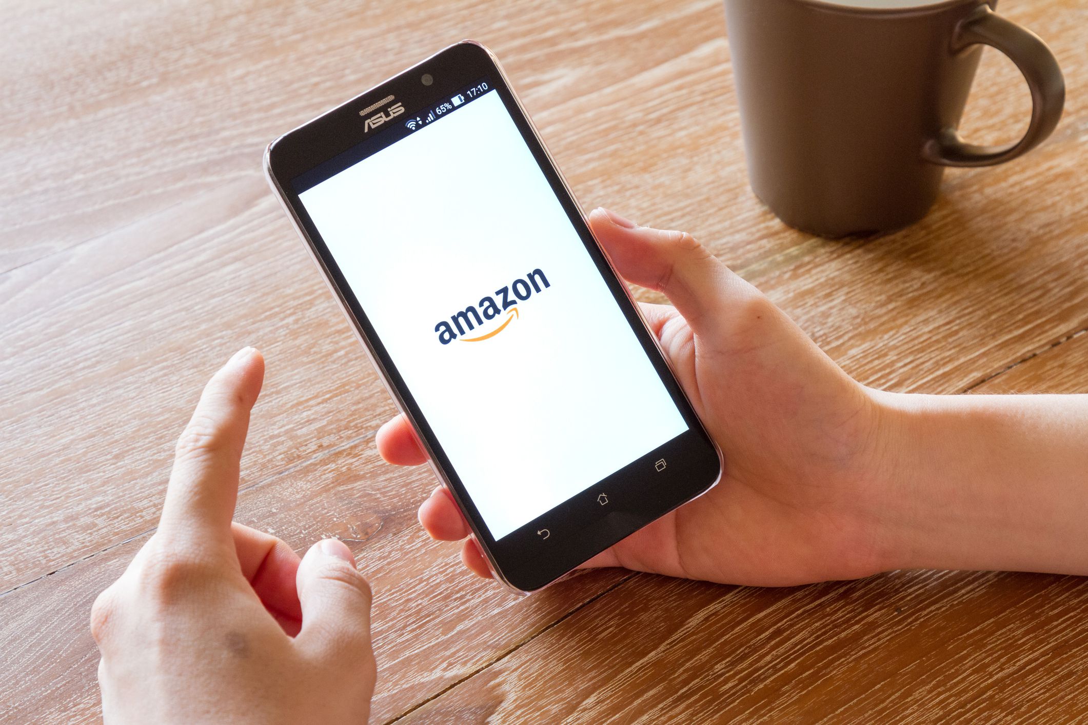 man hand holding screen shot of Amazon application showing on Asus Zenfone 2 mobile phone