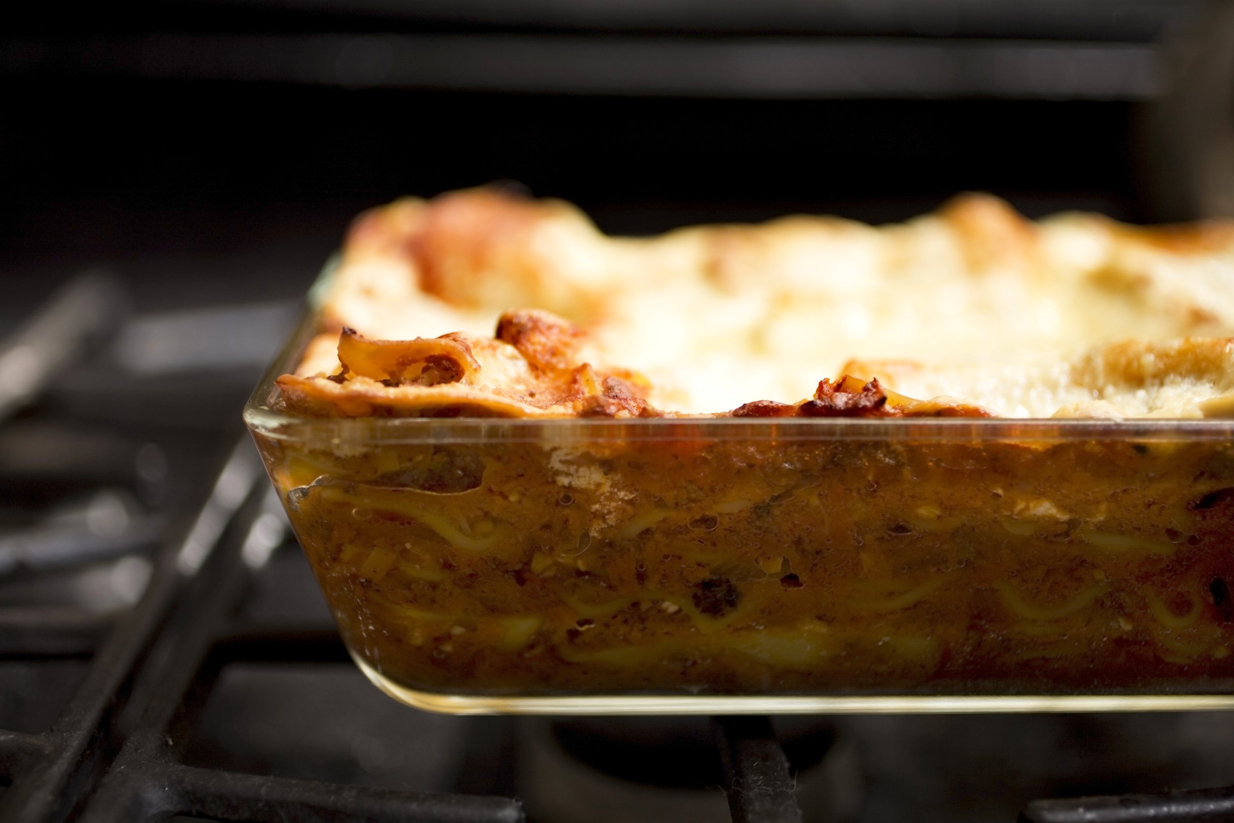 Lasagna in a glass baking dish in the oven