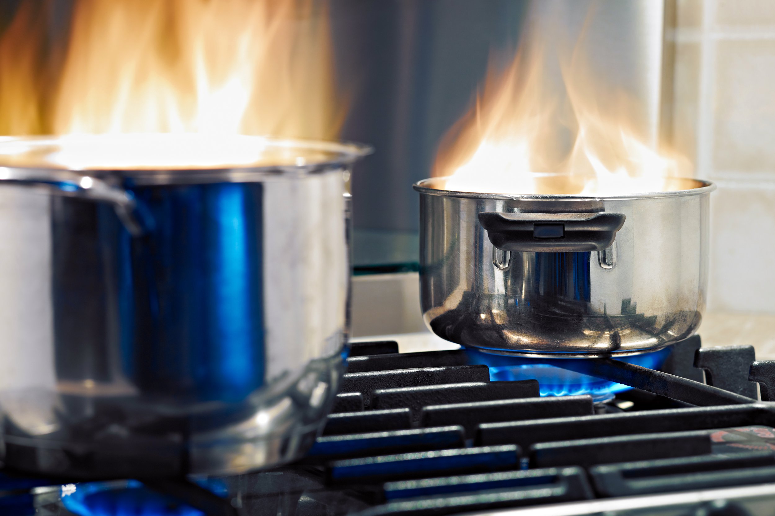 Two pots on fire on a stove