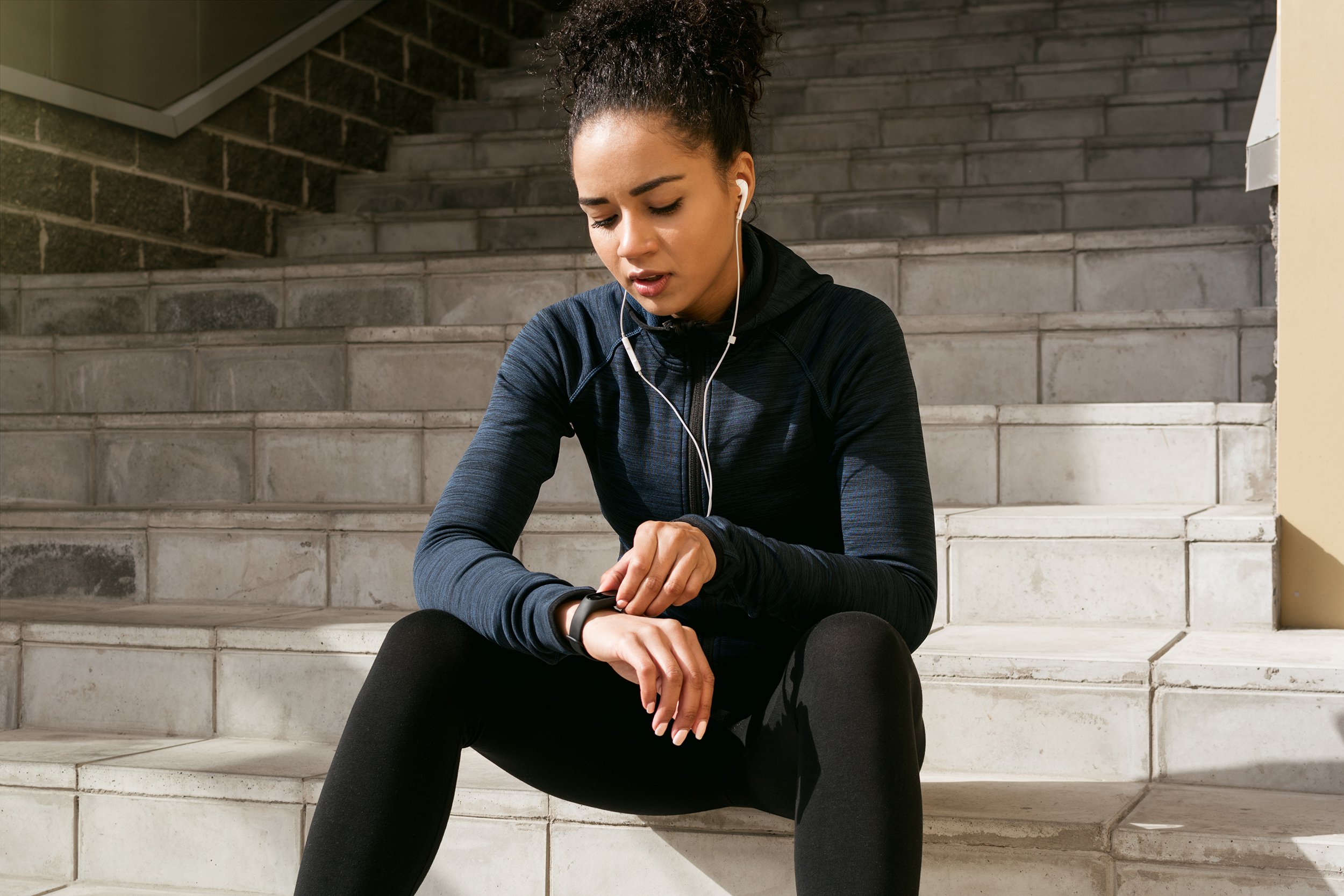 young female runner checking her pulse