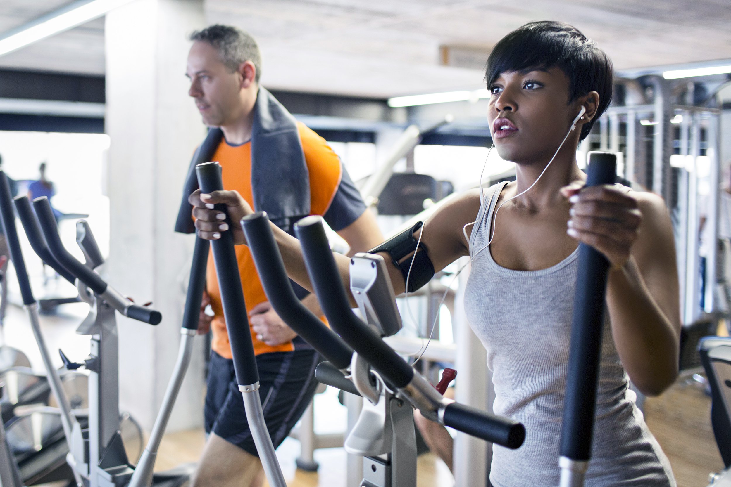 two people at gym working out on elliptical