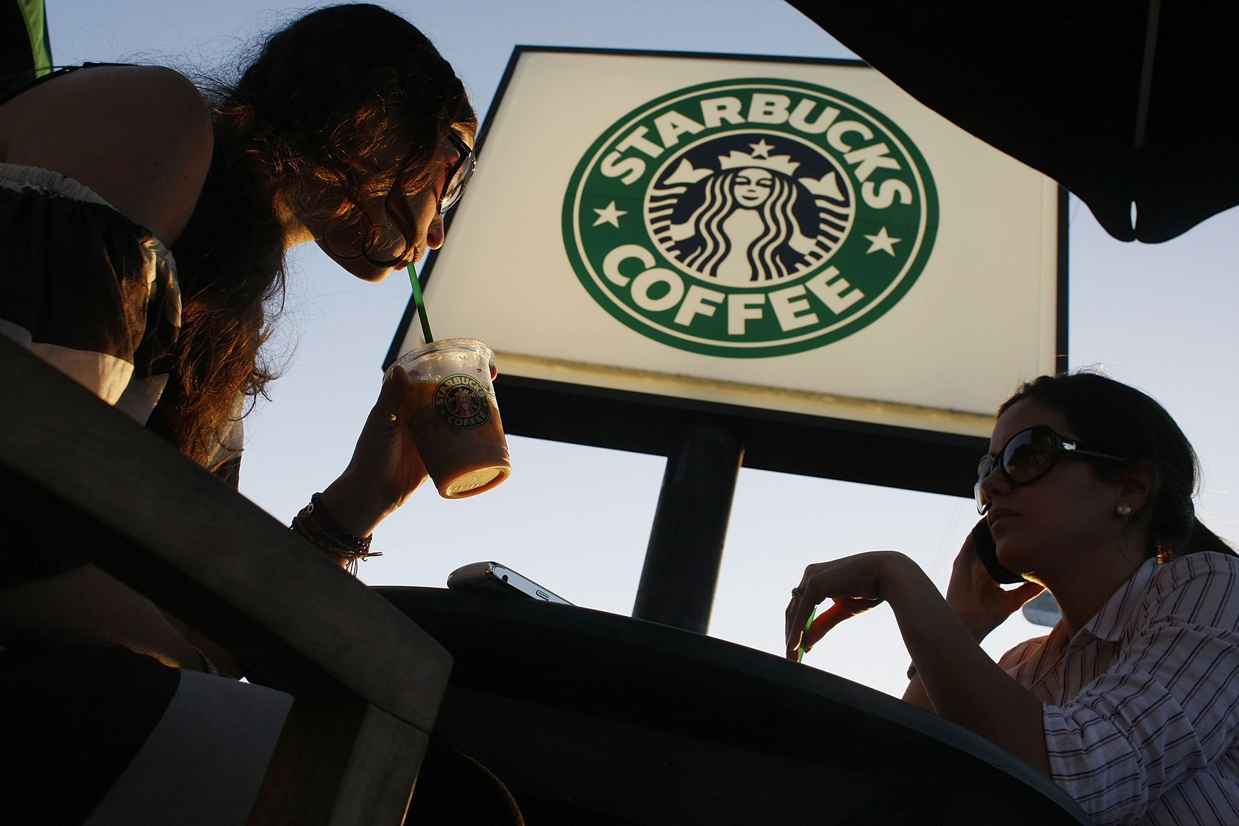 Customers relax and drink their beverages at a Starbucks Coffee shop on January 28, 2009 in Miami, Florida.