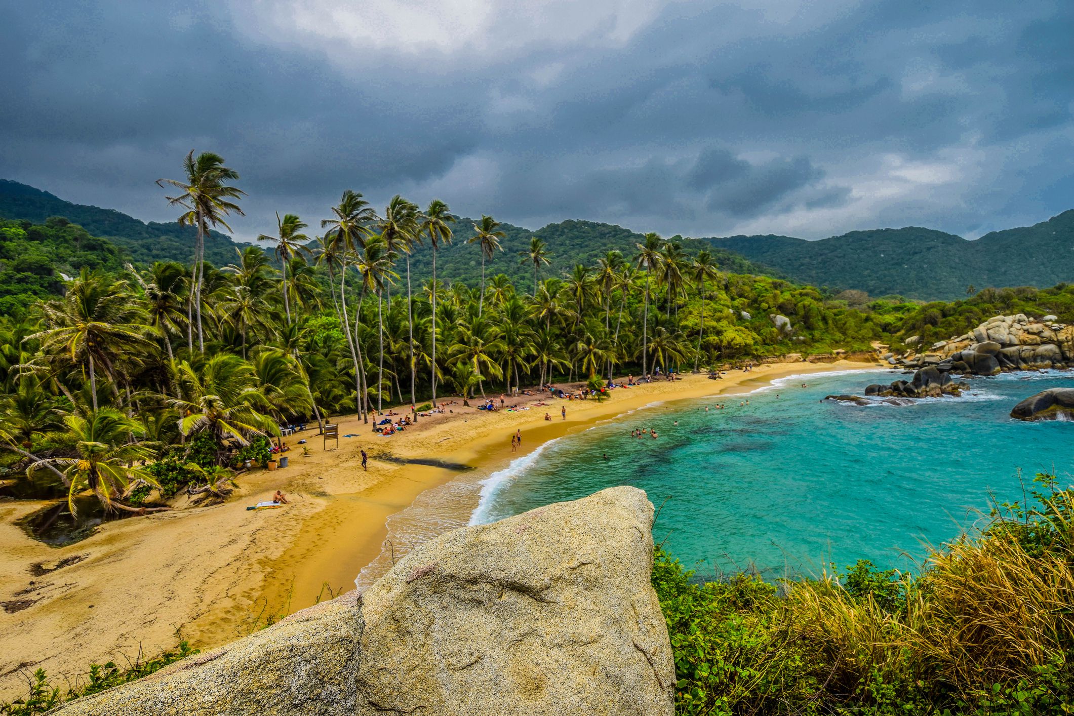 Beaches and palm trees of Cabo San Juan, Tayrona National Park, Colombia during a cloudy day with mountains in the background