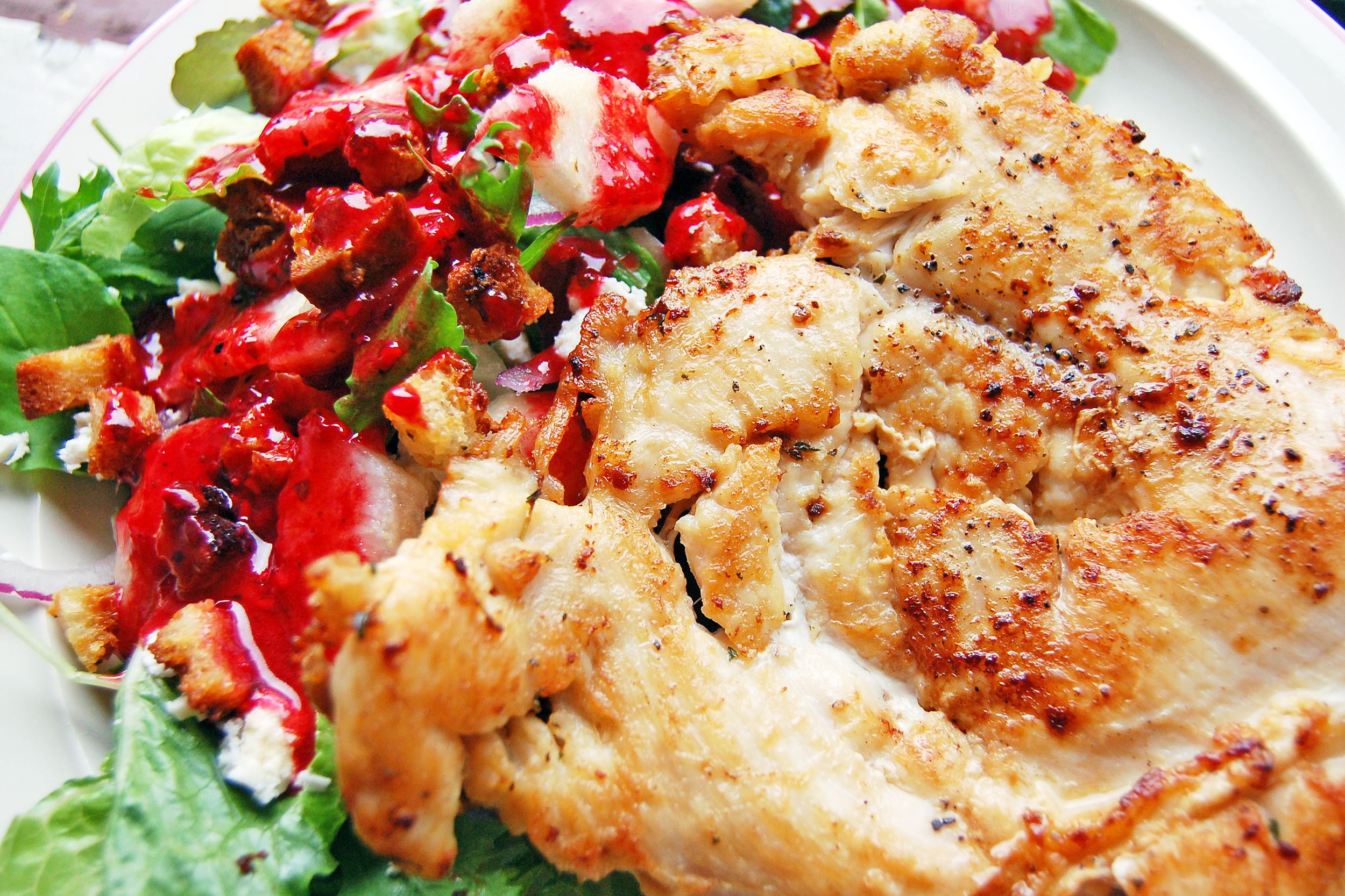 Chicken paillard and salad on a white plate
