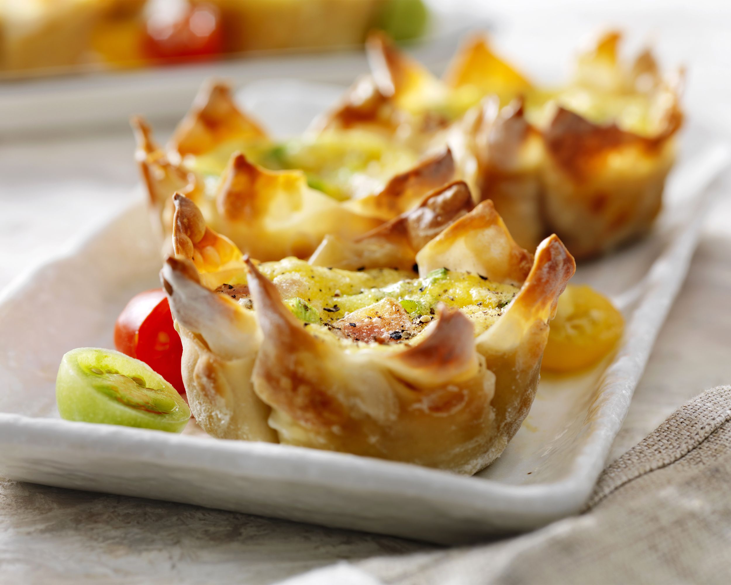 Closeup of blt wonton crunchies on a white ceramic rectangle plate on a natural napkin blurred into the background