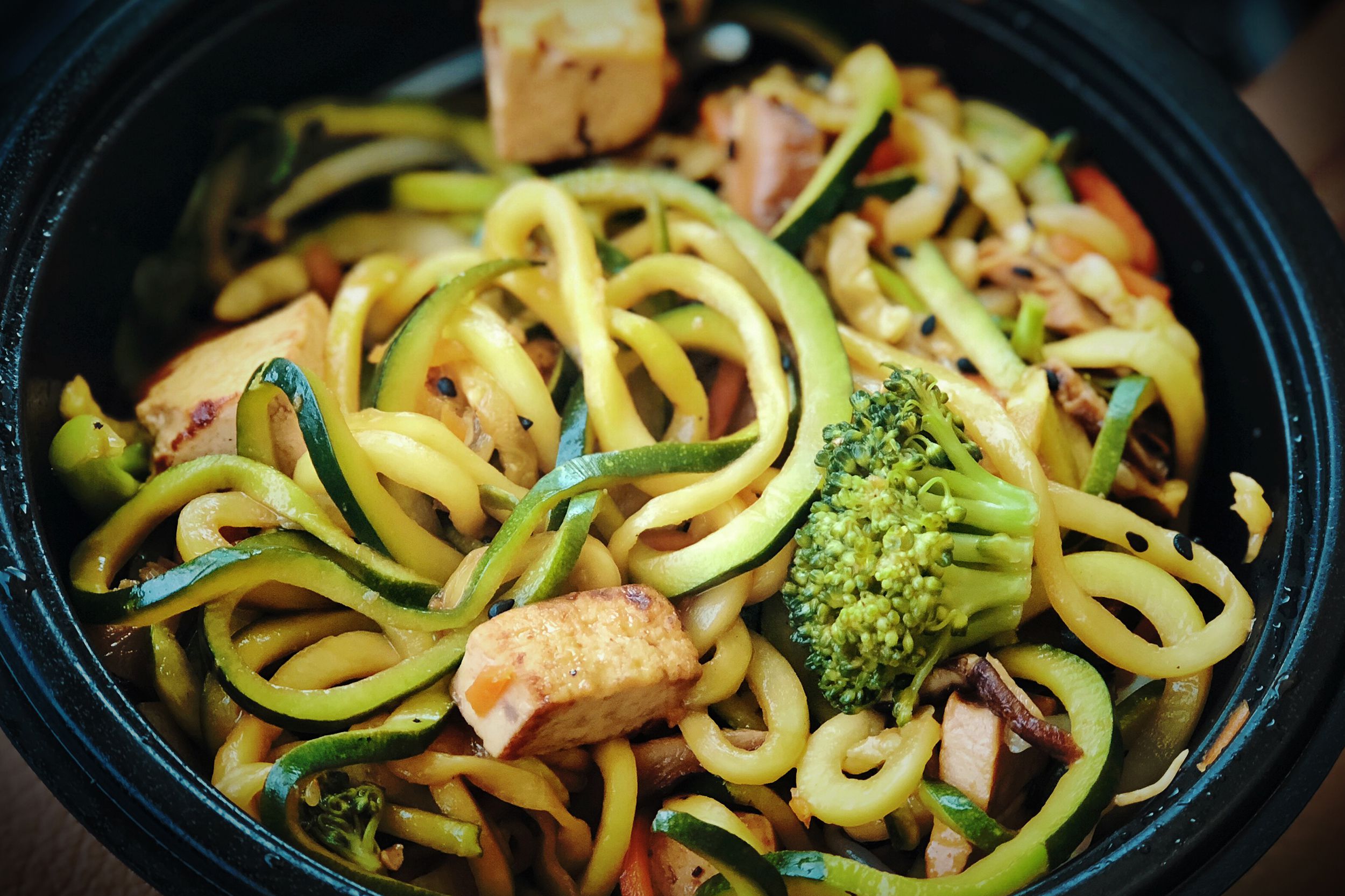 Closeup of zoodle soup at Noodles & Company in a black bowl