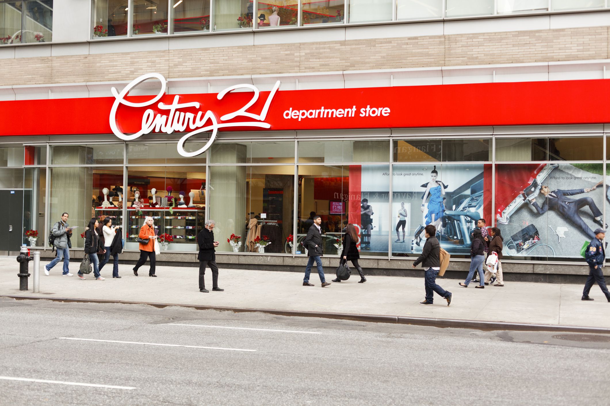 Front exterior of Century 21 Department Store on Broadway, New York City, with numerous people walking on the street in front, on a sunny, winter day