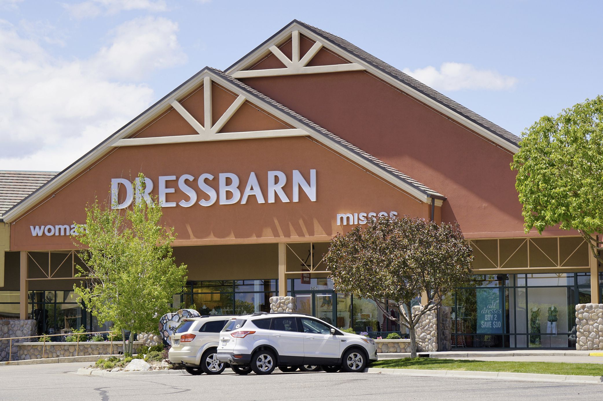 Front exterior of Dressbarn, Loveland, Colorado, two cars in the parking lot is in the foreground three trees in bloom during late spring