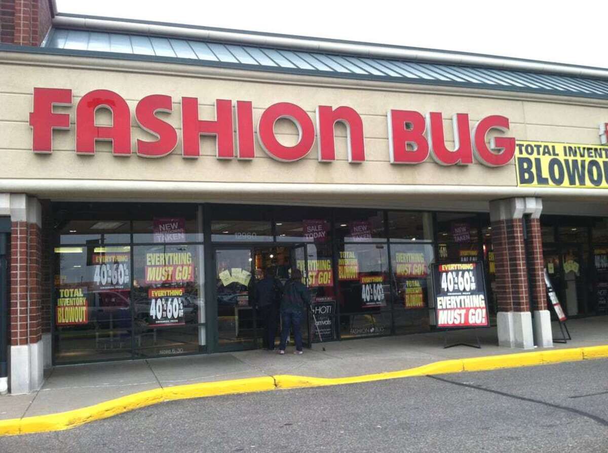 Front exterior of Fashion Bug store, Coon Rapids, Minnesota, several store closing signs in the windows and glass doors, two people are going through the doors, one with a walking cane, during winter