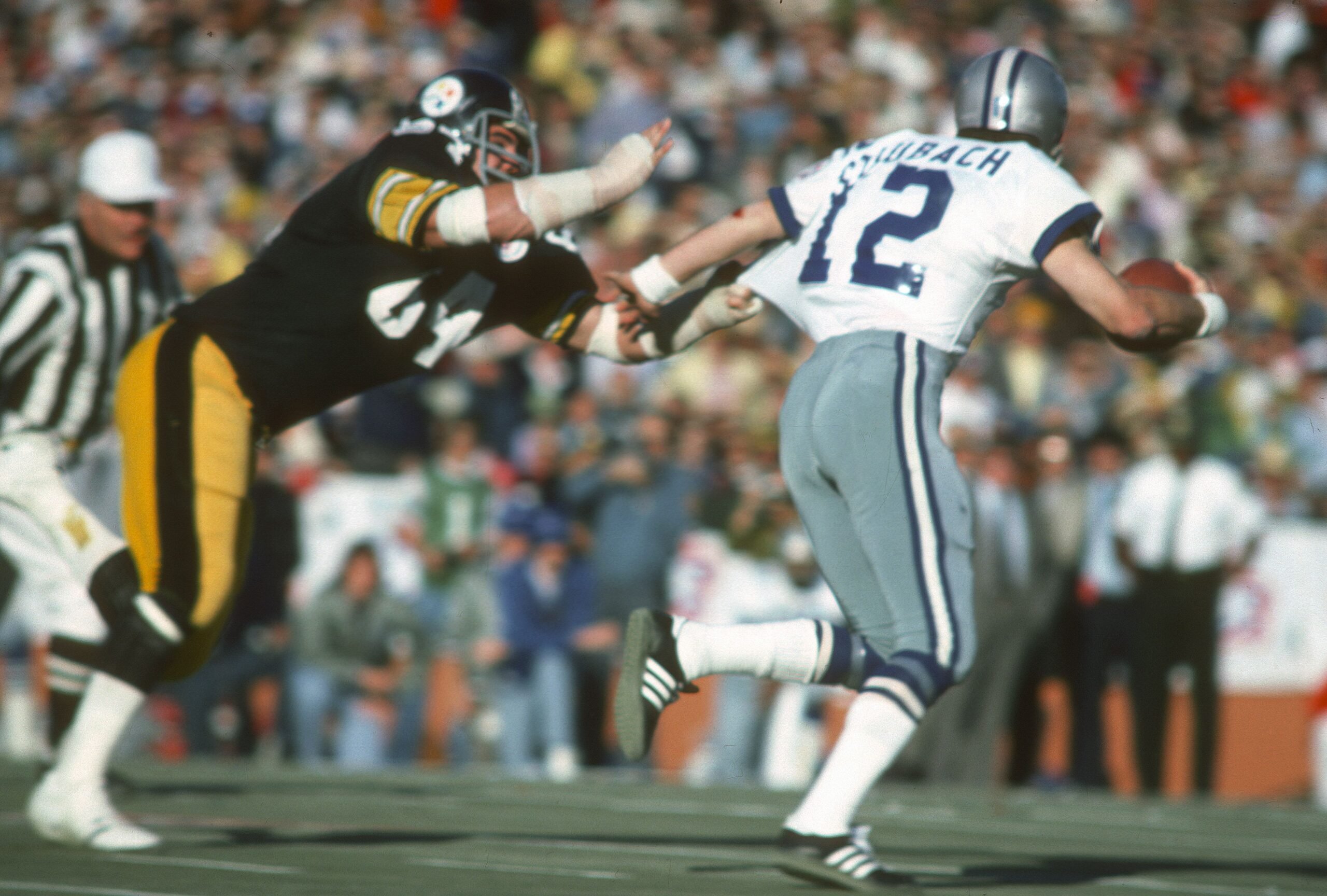 Roger Staubach #12 of the Dallas Cowboys scrambles with the ball pursued by Steve Furness #64 of the Pittsburgh Steelers during Super Bowl X on January 18, 1976