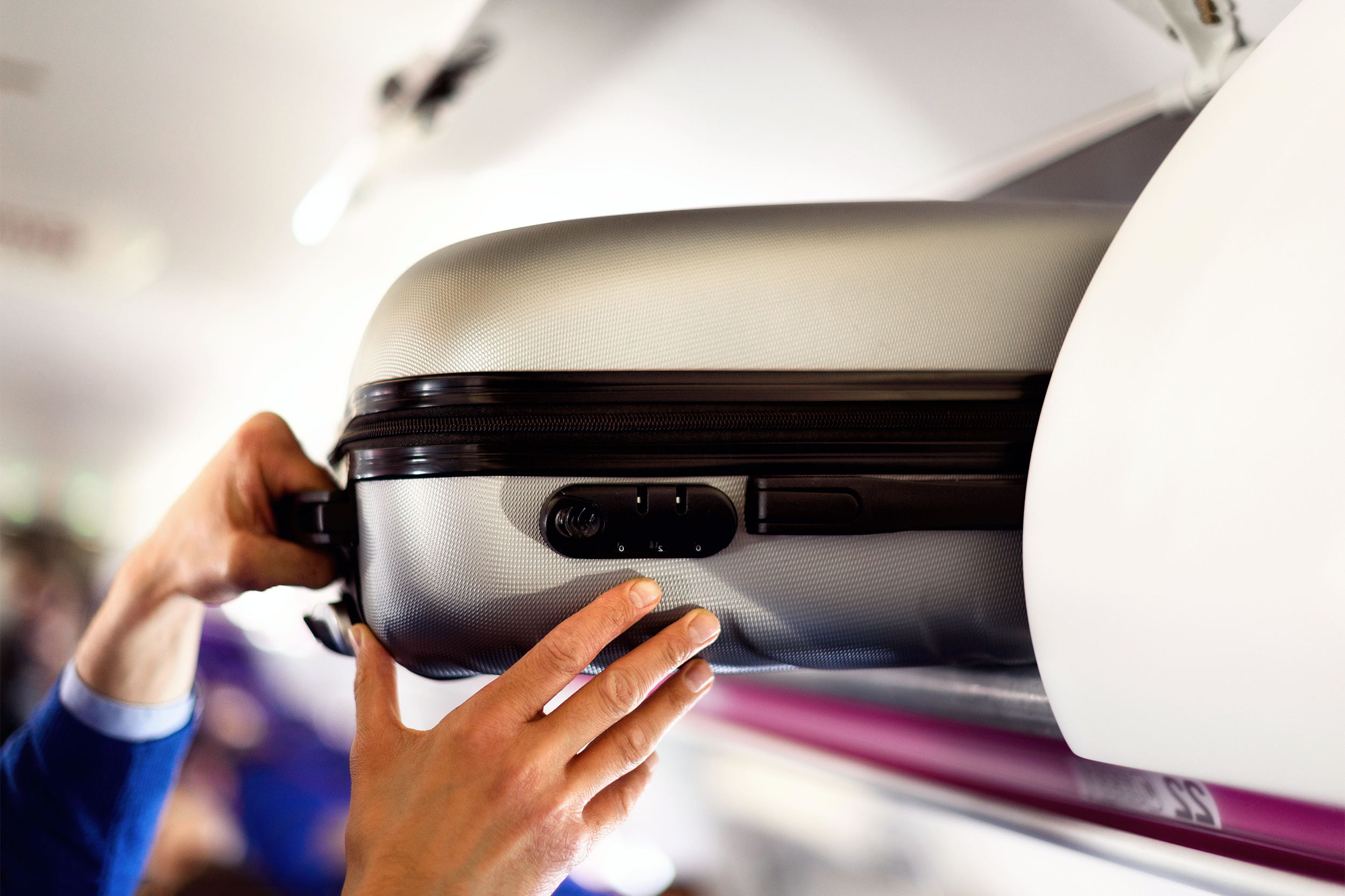 Putting suitcase in overhead compartment