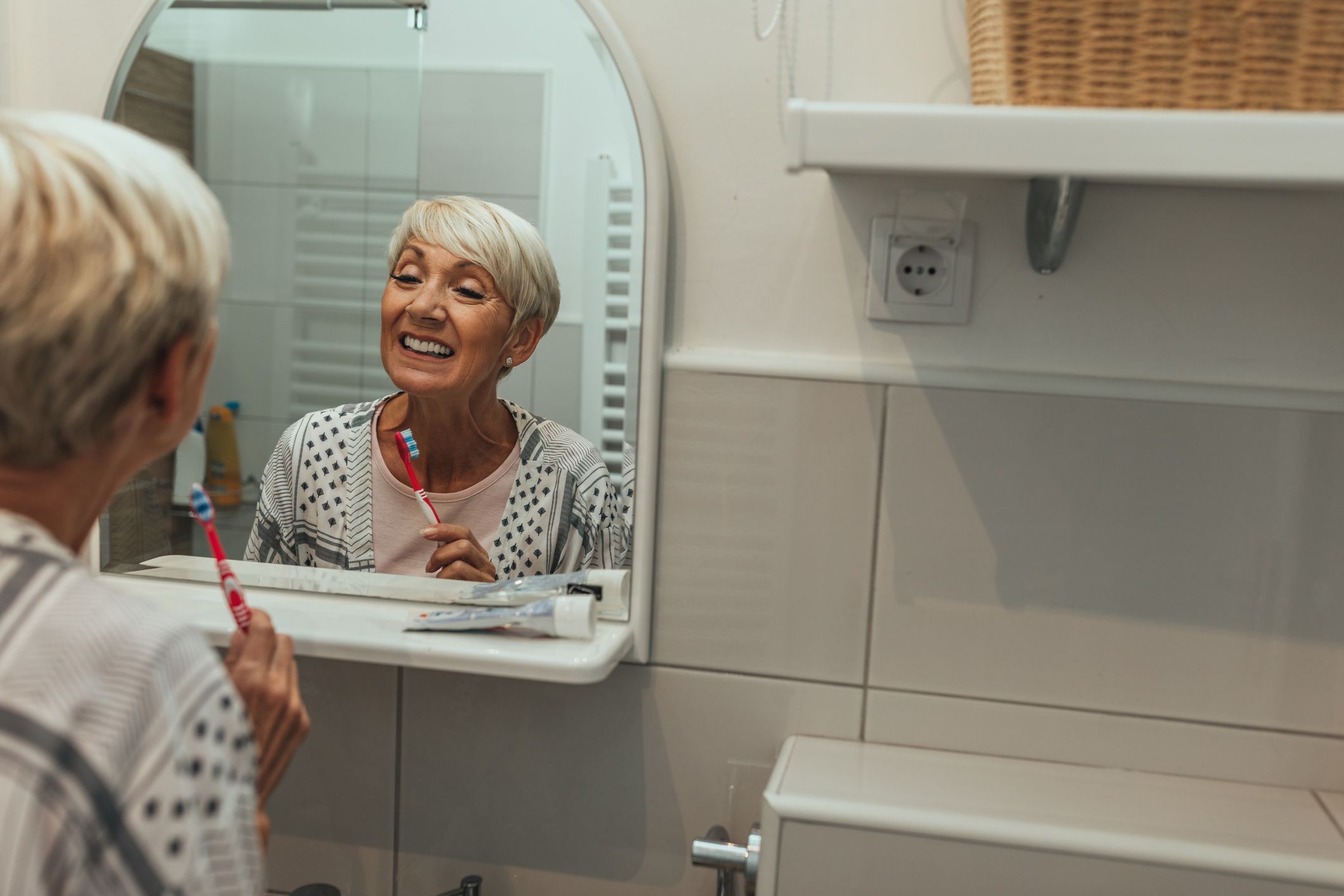 Cropped shot of a senior lady brushing her teeth in the bathroom