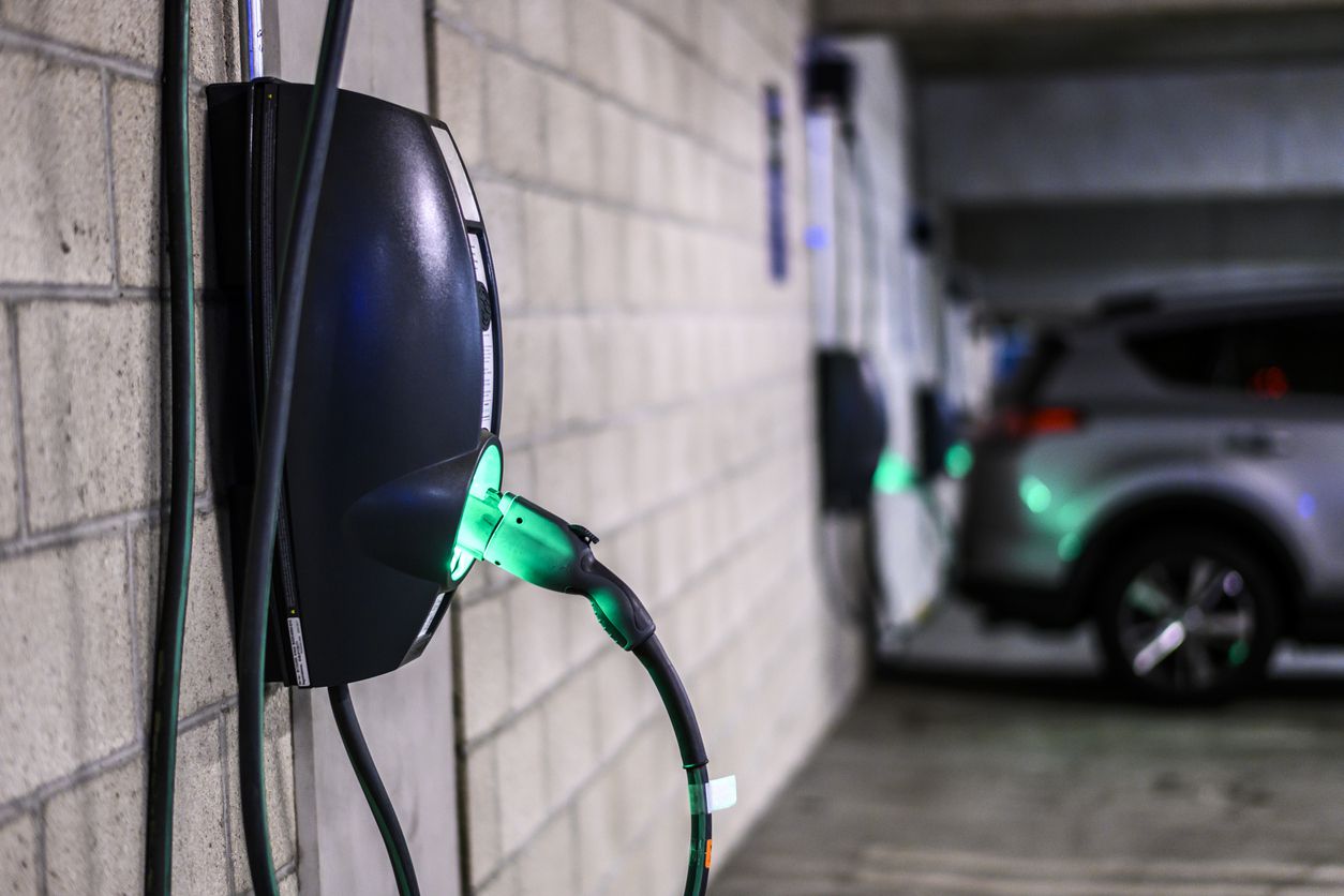 Power supply box in an electric vehicle charging station parking lot in a public garage.