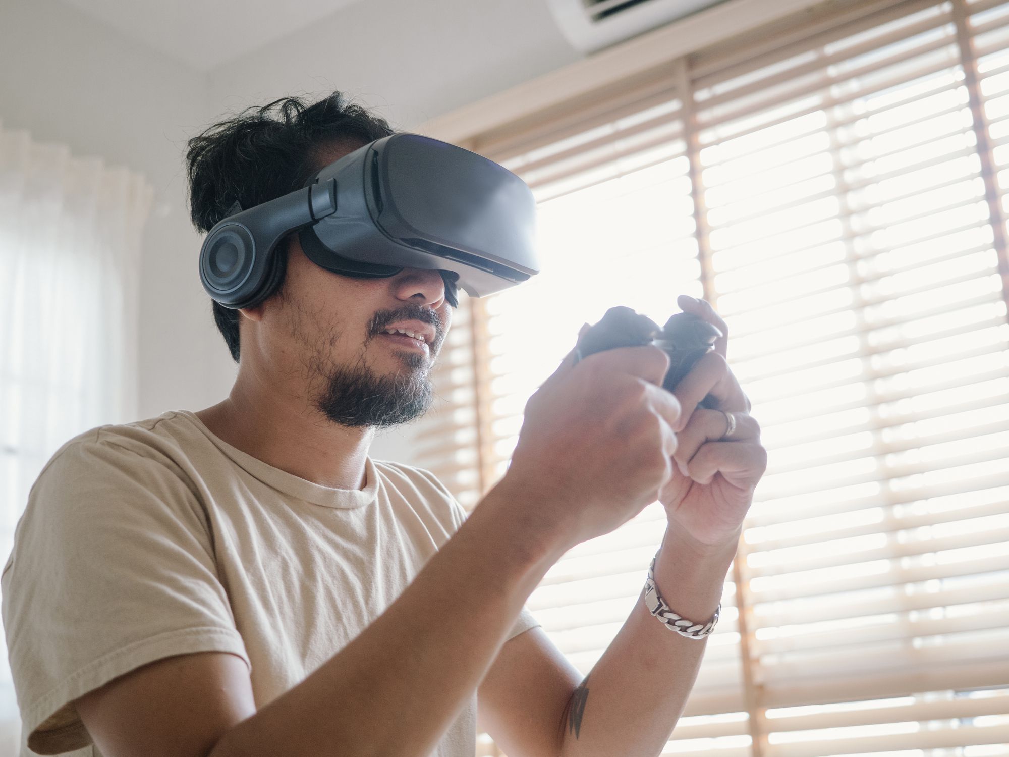 Asian hipster man having fun playing video games at home