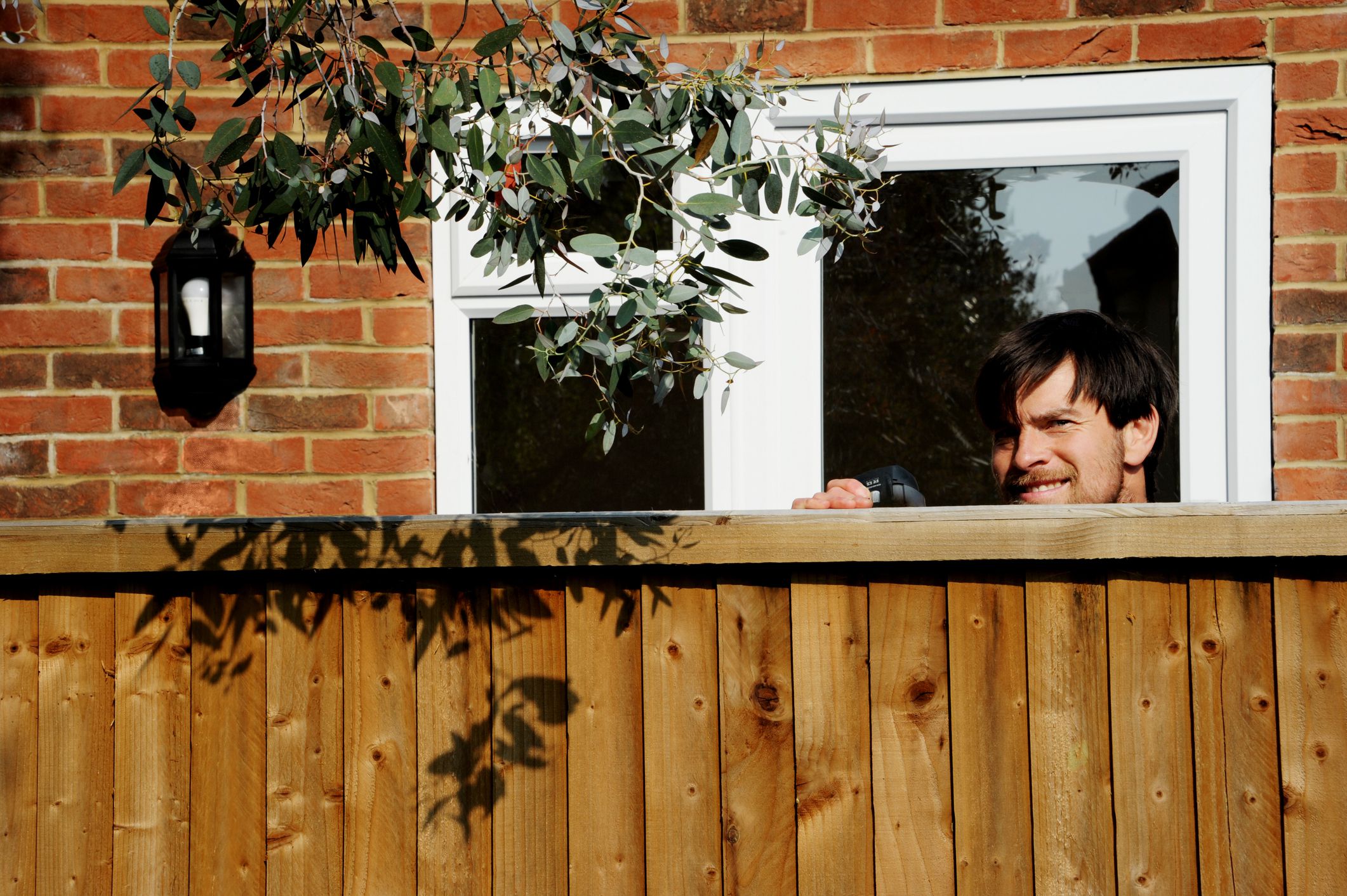 Super obnoxious nosy neighbour peeking over the fence while spying on the neighbours, acting like the covid-19 government snitch