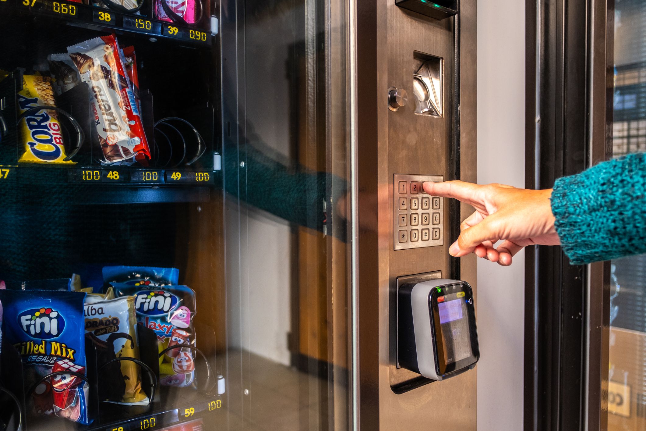 Valencia, Spain; 16th november 2021: A woman uses a vending machine to buy food and drink on the street.
