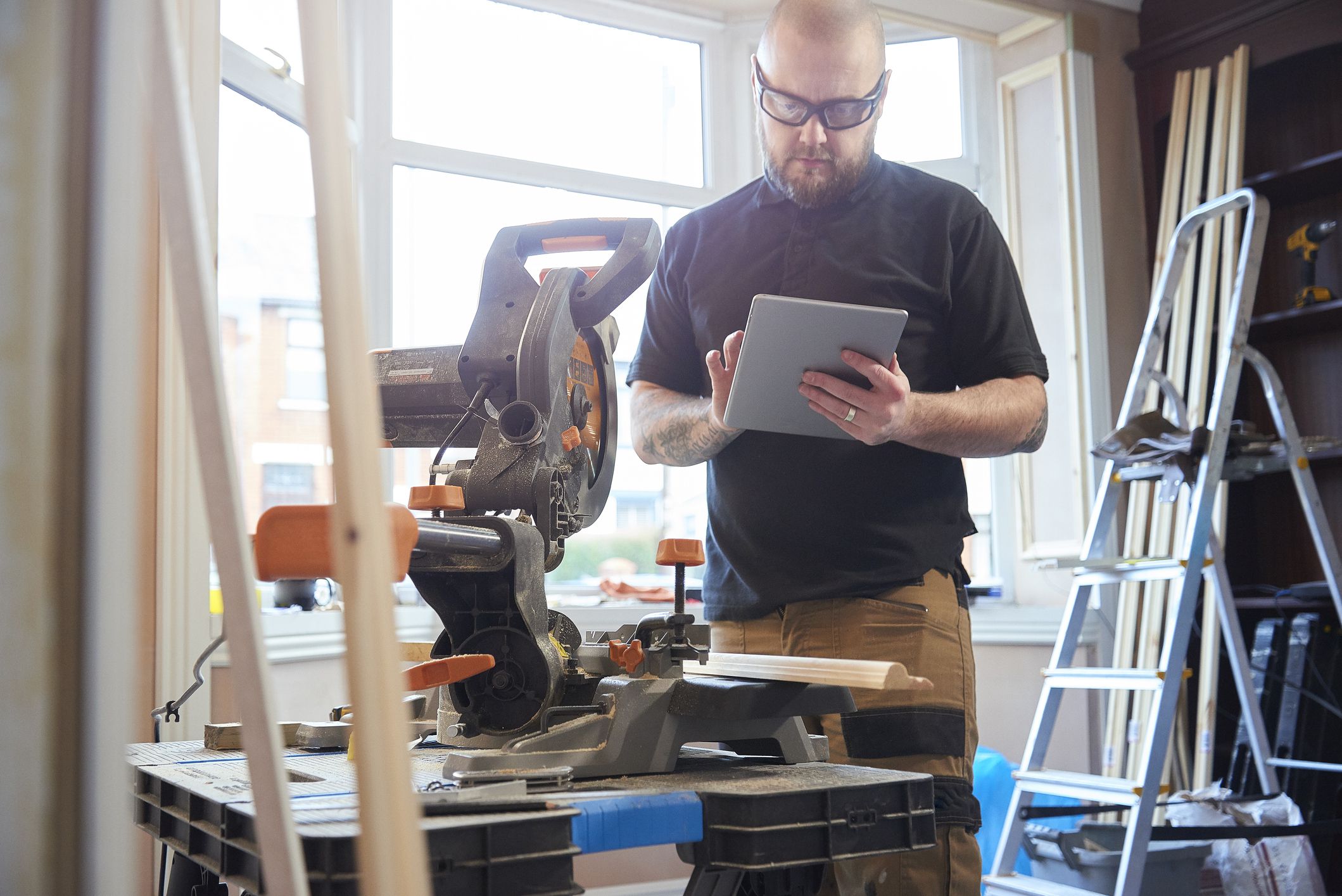 The owner of a small carpentry business ordering materials on his digital tablet