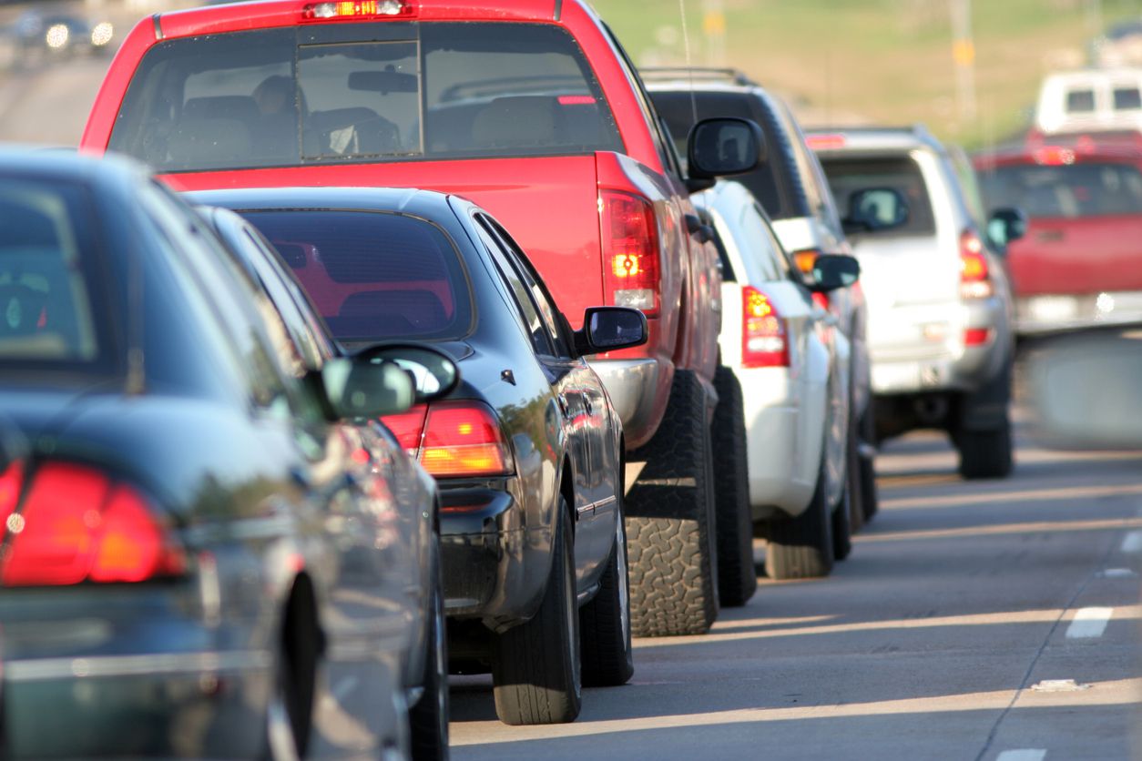A line of cars in afternoon rush hour traffic
