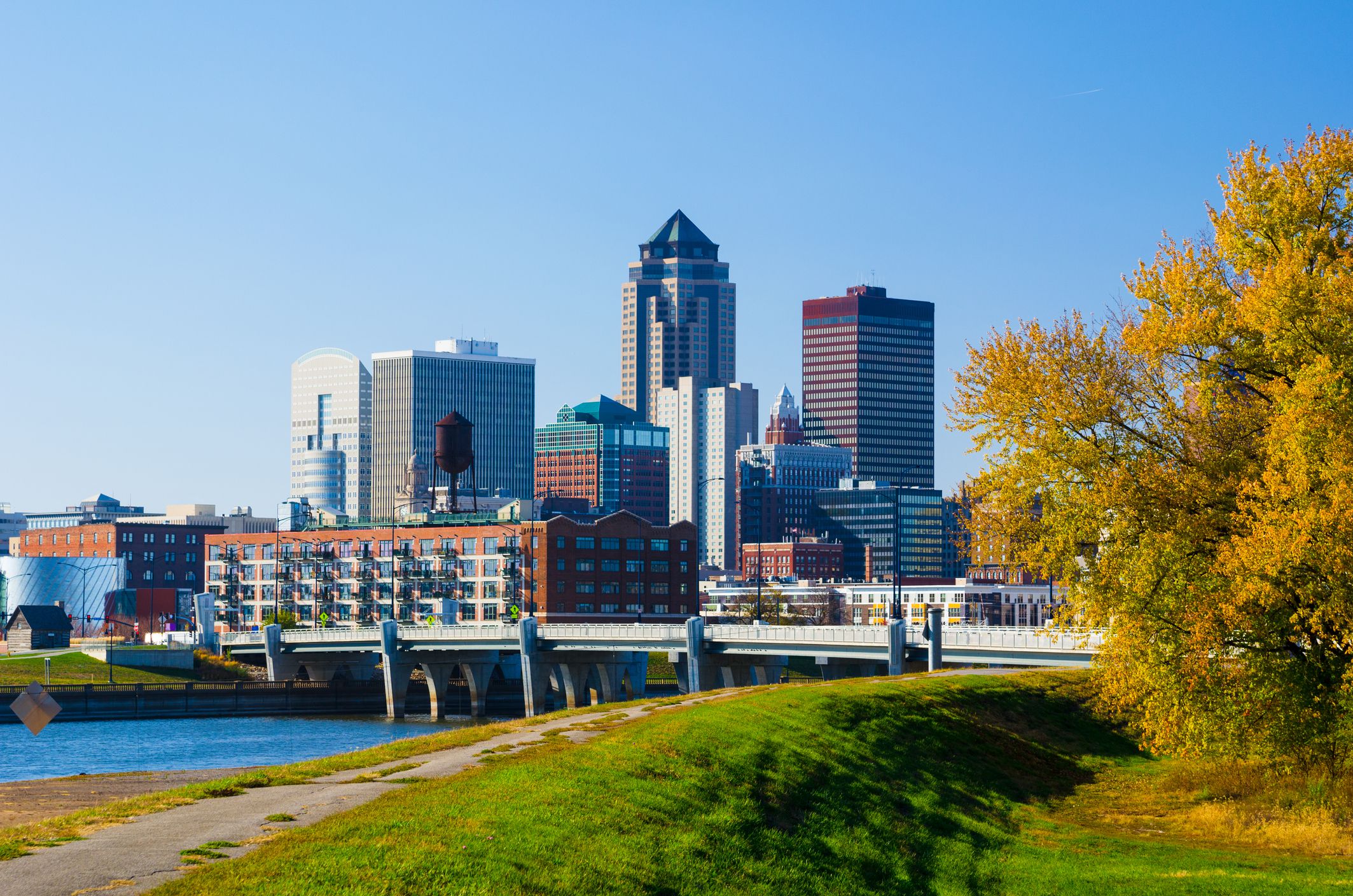 Des Moines Downtown Skyline, river, grass, and tree during Autumn.