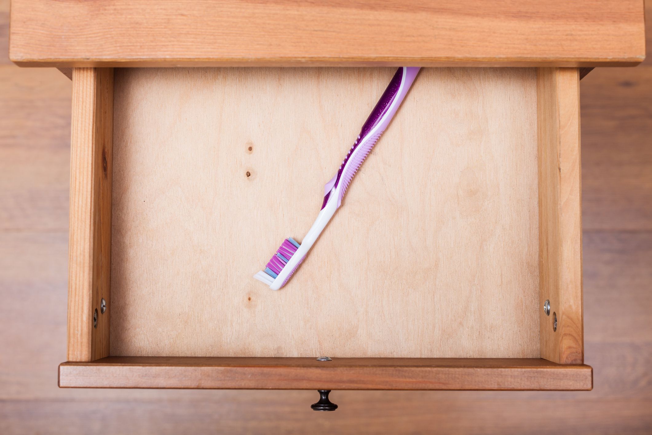 top view of toothbrush in open drawer of nightstand